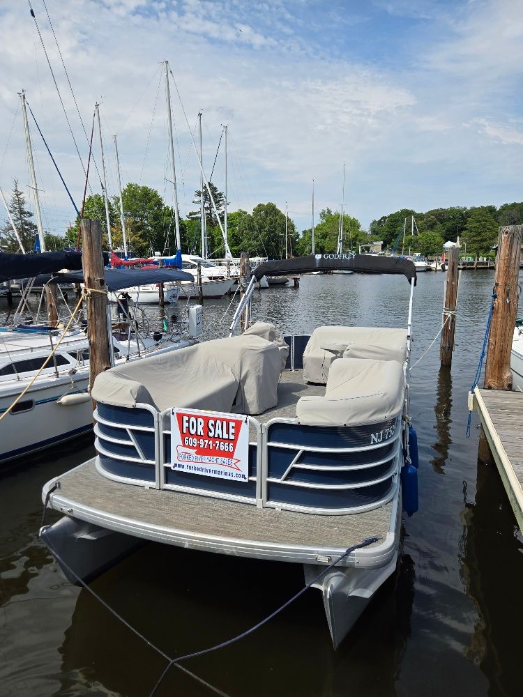 A 2022 Godfrey Sweetwater 2186C pontoon boat docked with a 'For Sale' sign displayed.