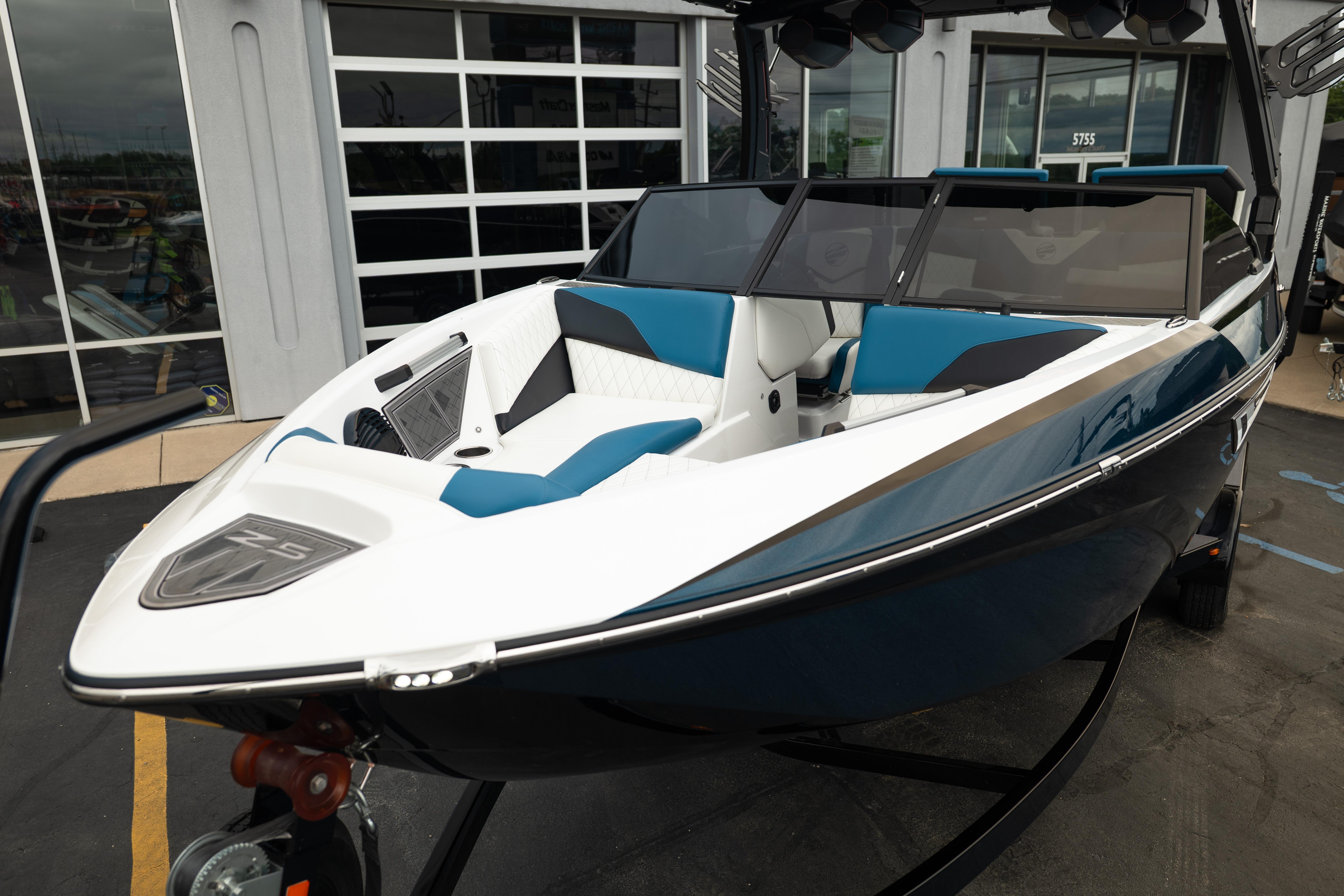 2024 Tigé Z5 boat with sleek design, blue and white interior, parked outside a showroom.