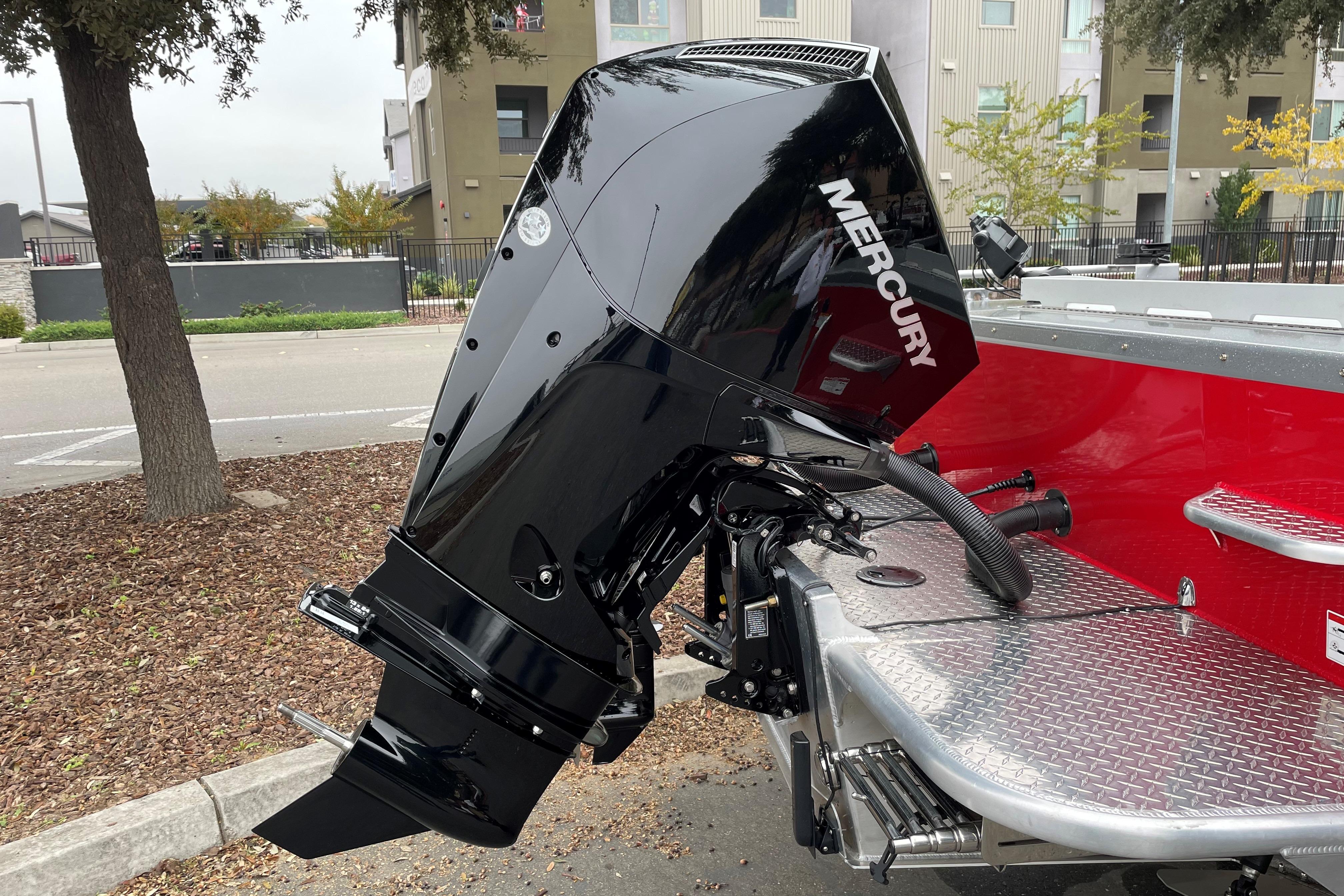 2024 Spartan 200 Astoria boat with Mercury outboard motor, parked outdoors.