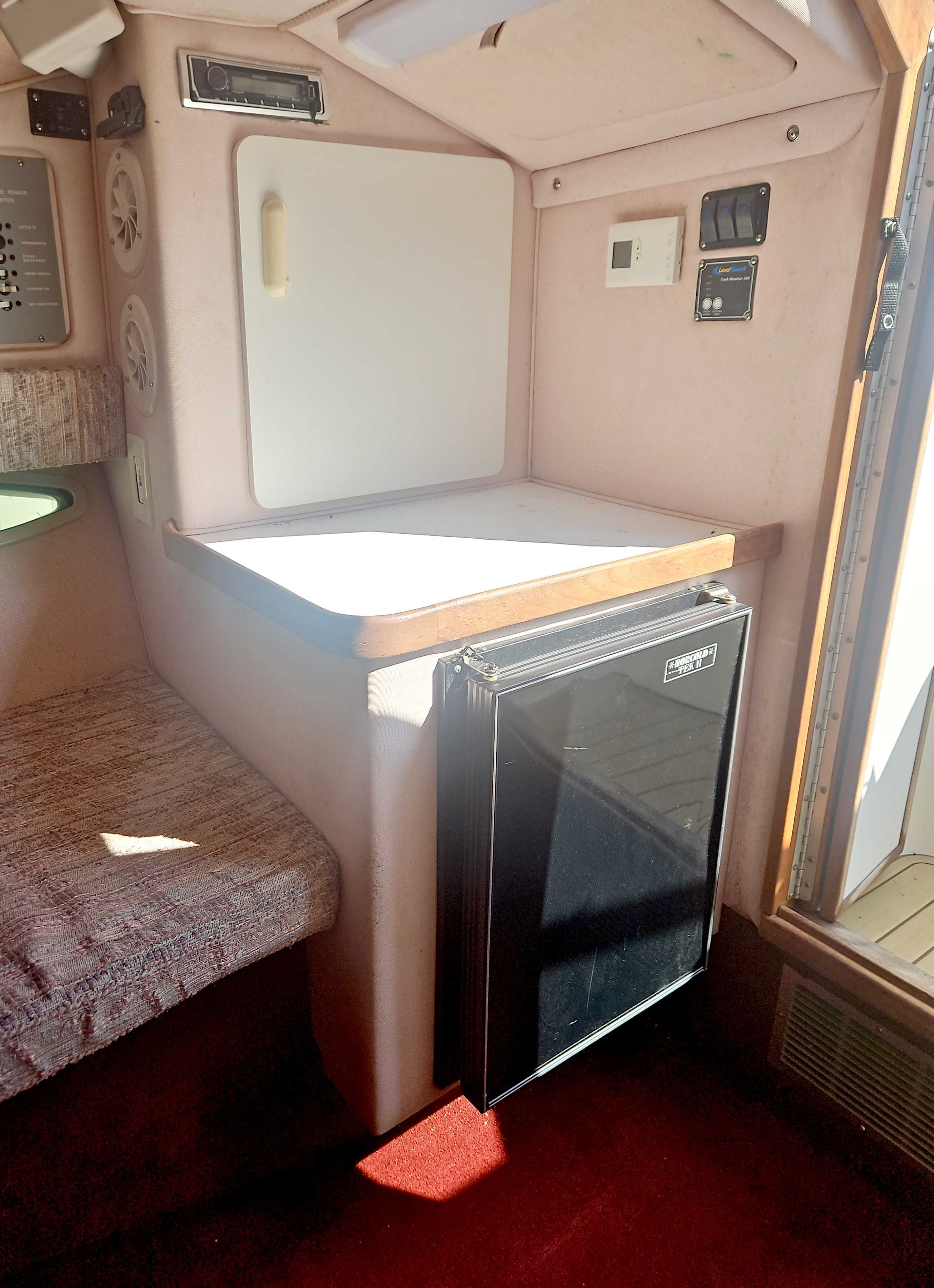 Interior of a 1989 Sea Ray 260 Overnighter with a fridge and seating area.