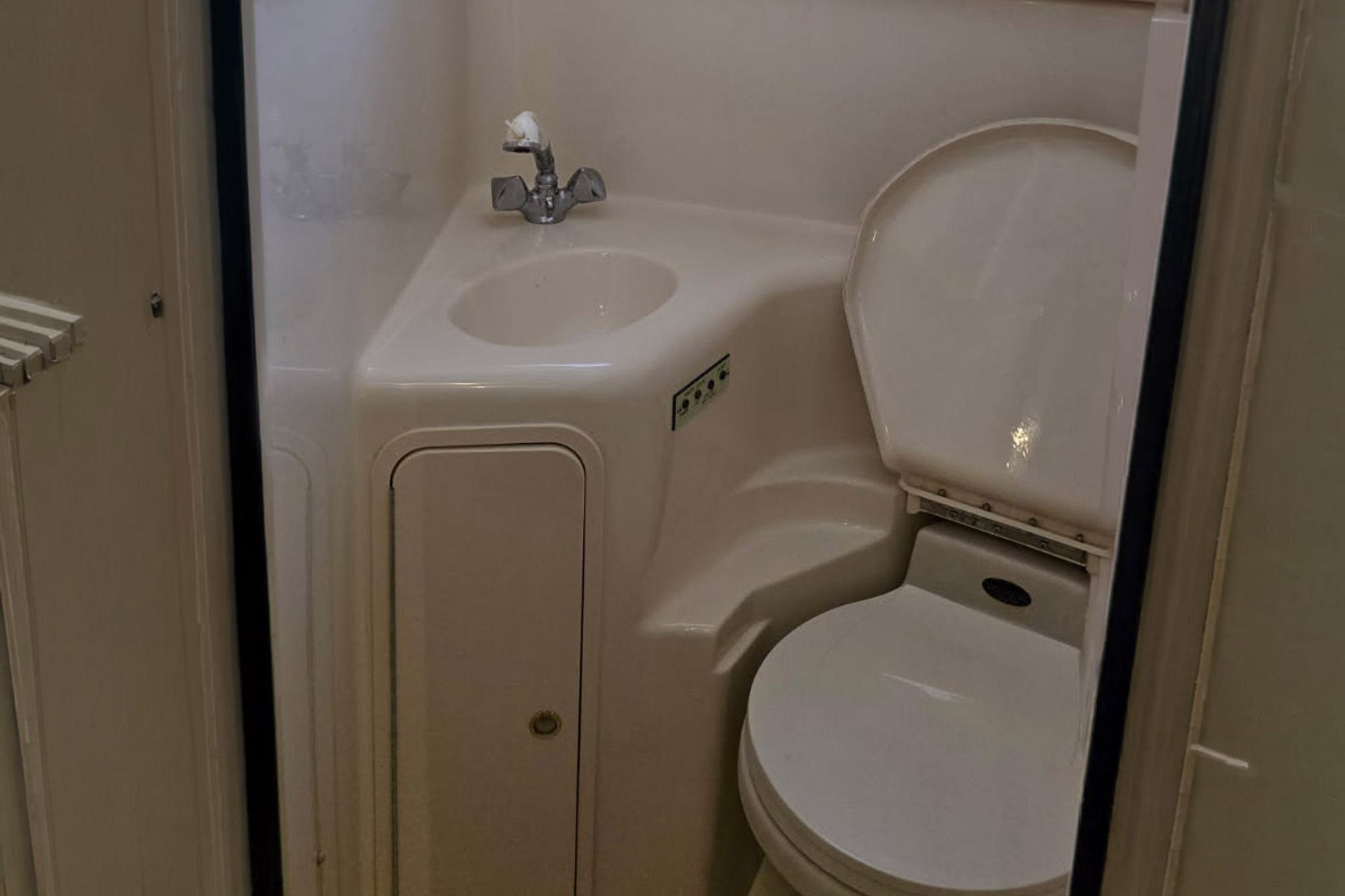 Compact bathroom in 1998 Sea Ray Sundancer 400 yacht with sink and toilet.