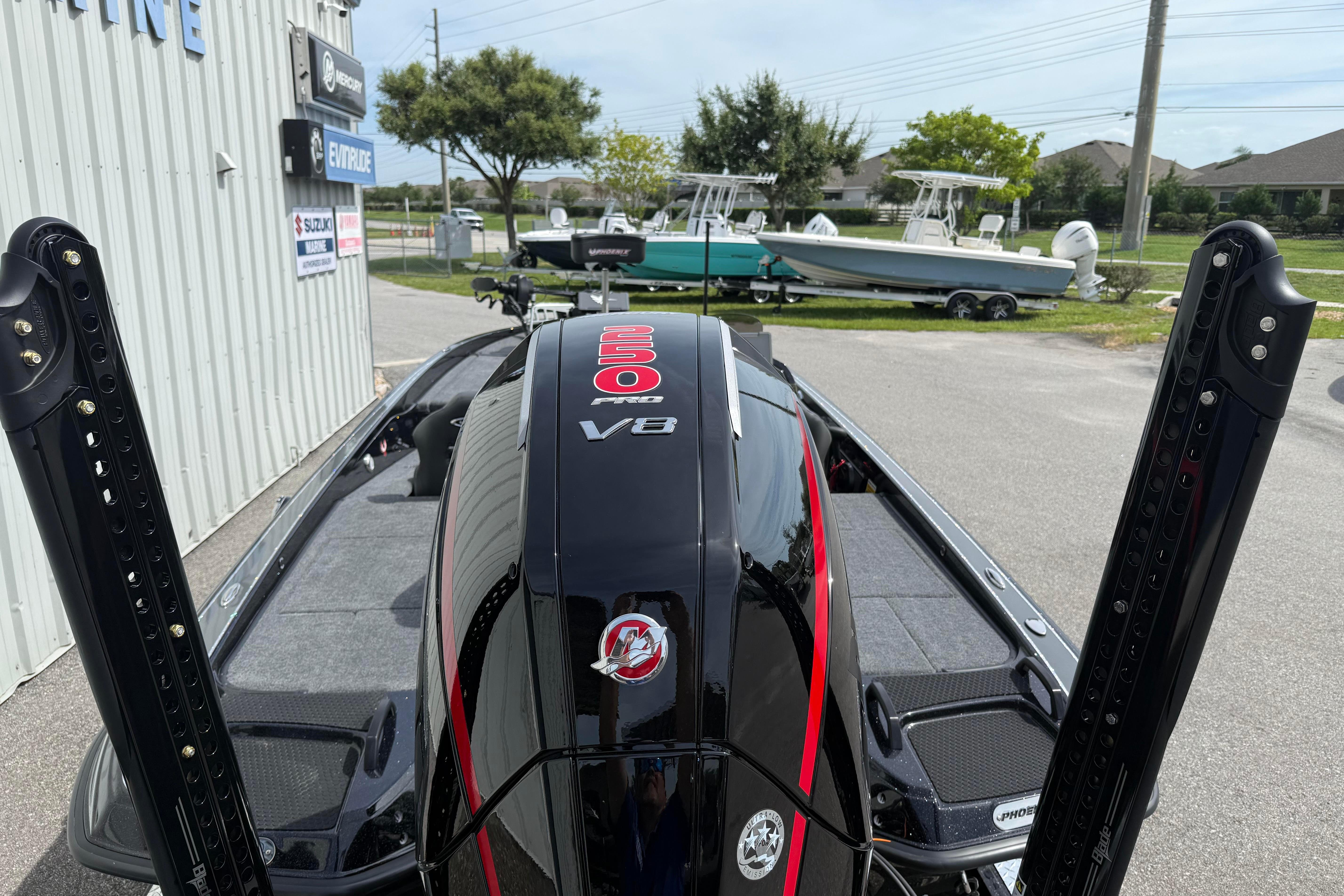 Phoenix 921 Elite X 2027 boat with powerful V8 engine, parked near marine shop.