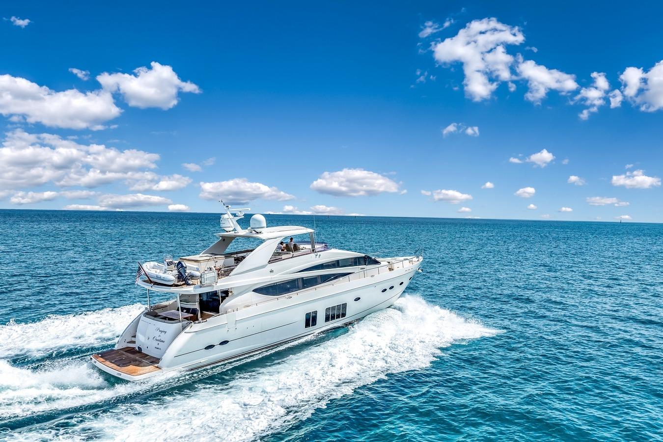 Luxury Princess 85 yacht cruising on open sea under clear blue sky.