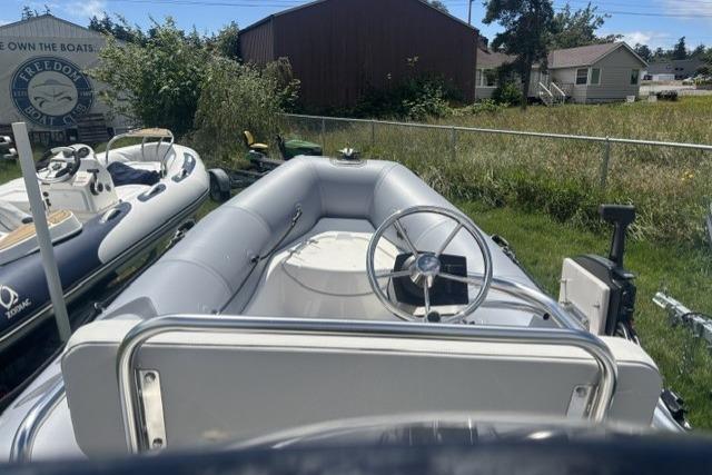 2024 Zodiac Pro 420 inflatable boat with steering wheel, parked outdoors.