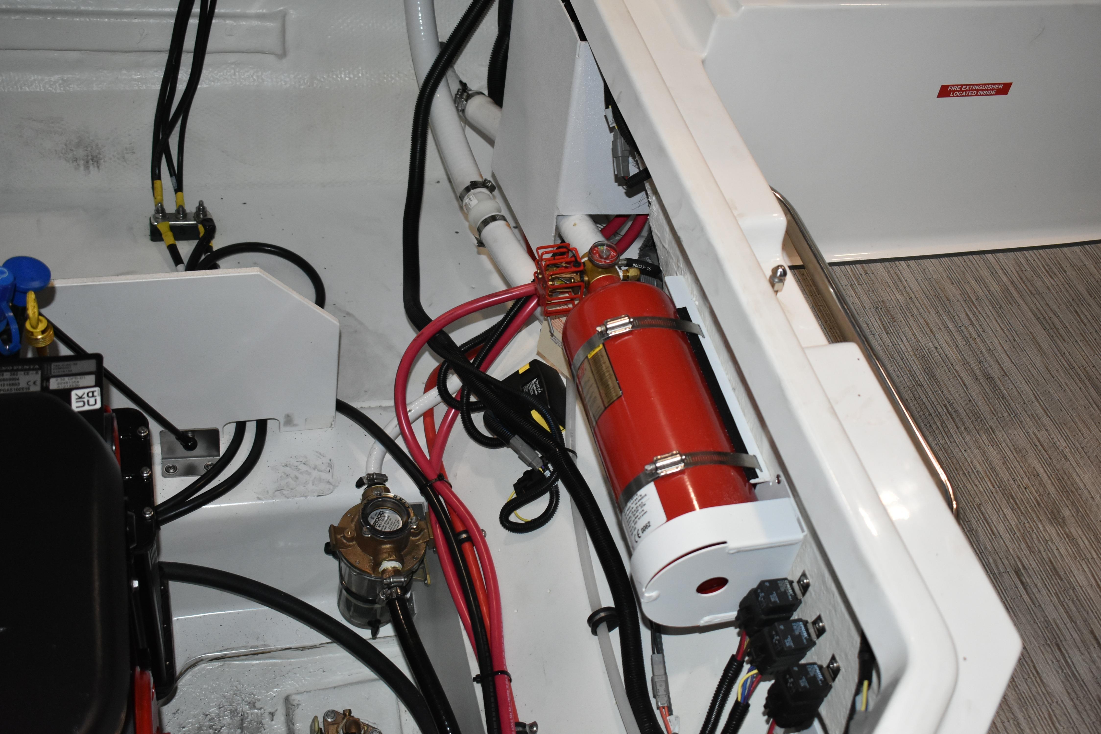 Engine compartment of 2023 Cobalt R8 boat with fire extinguisher and wiring.