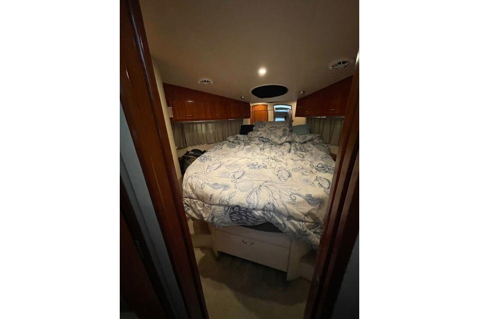 Interior cabin of 2003 Carver 36 Super Sport yacht with cozy bed and wooden cabinets.
