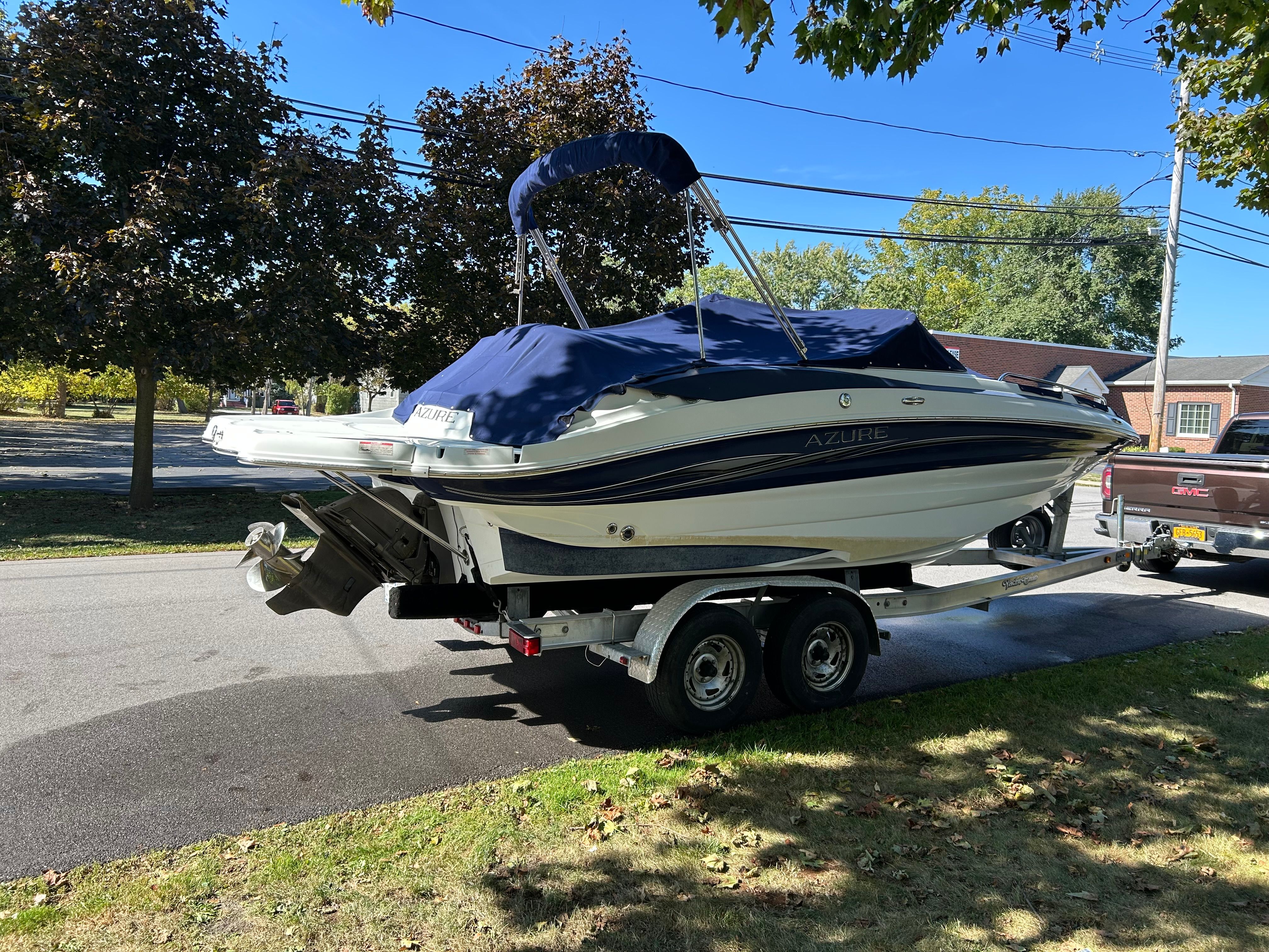 A 2008 Azure AZ220 boat on a trailer in a residential area.