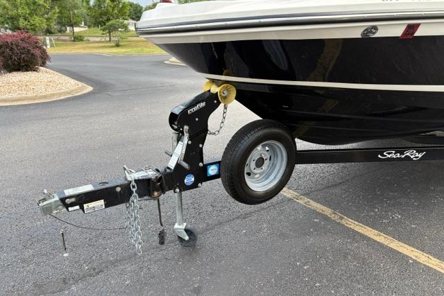 2017 Searay SPX210 boat on trailer, parked on asphalt, featuring black hull and trailer hitch.