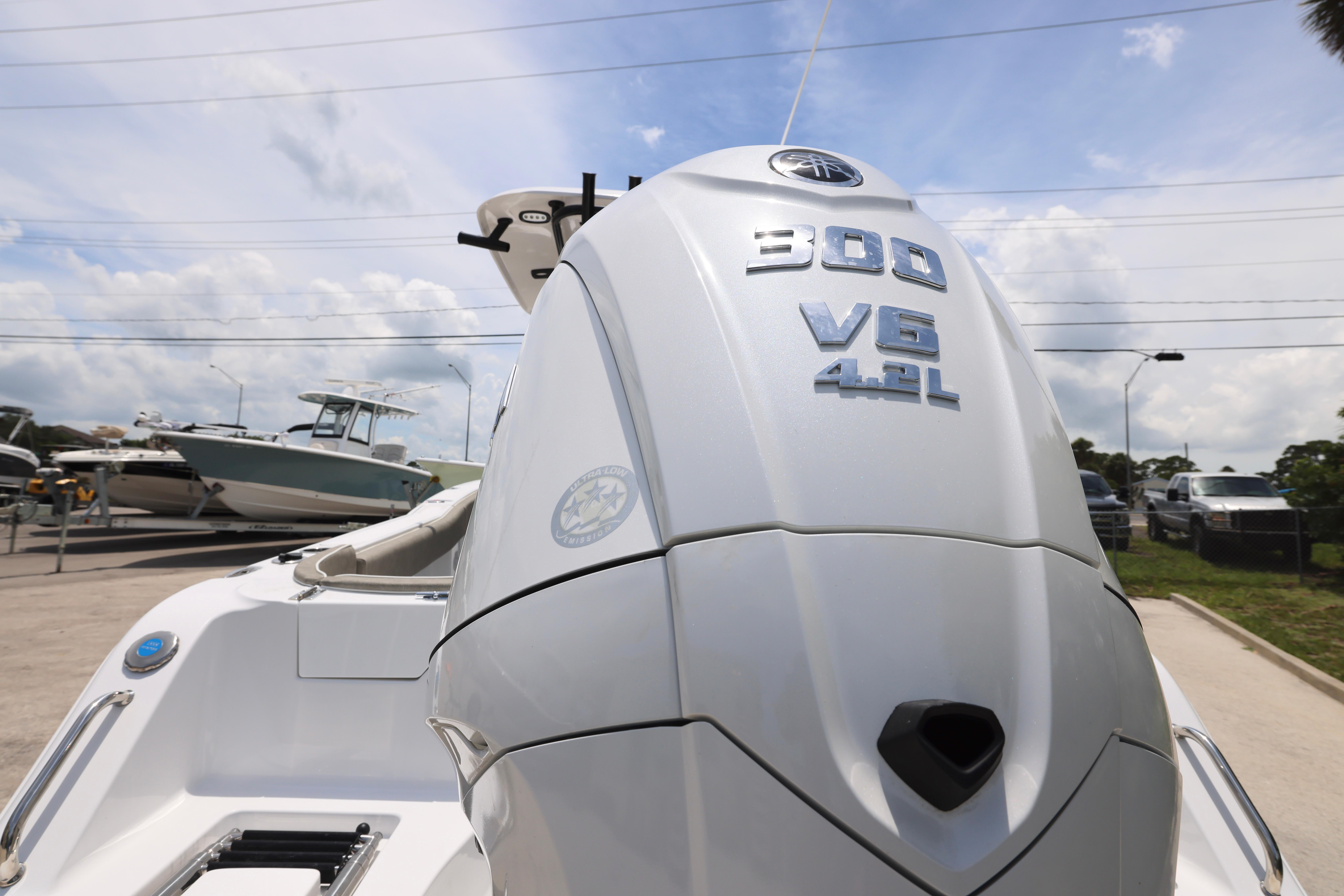 2026 Sea Hunt Ultra 245 SE boat with 300 V6 4.2L engine in a marina.