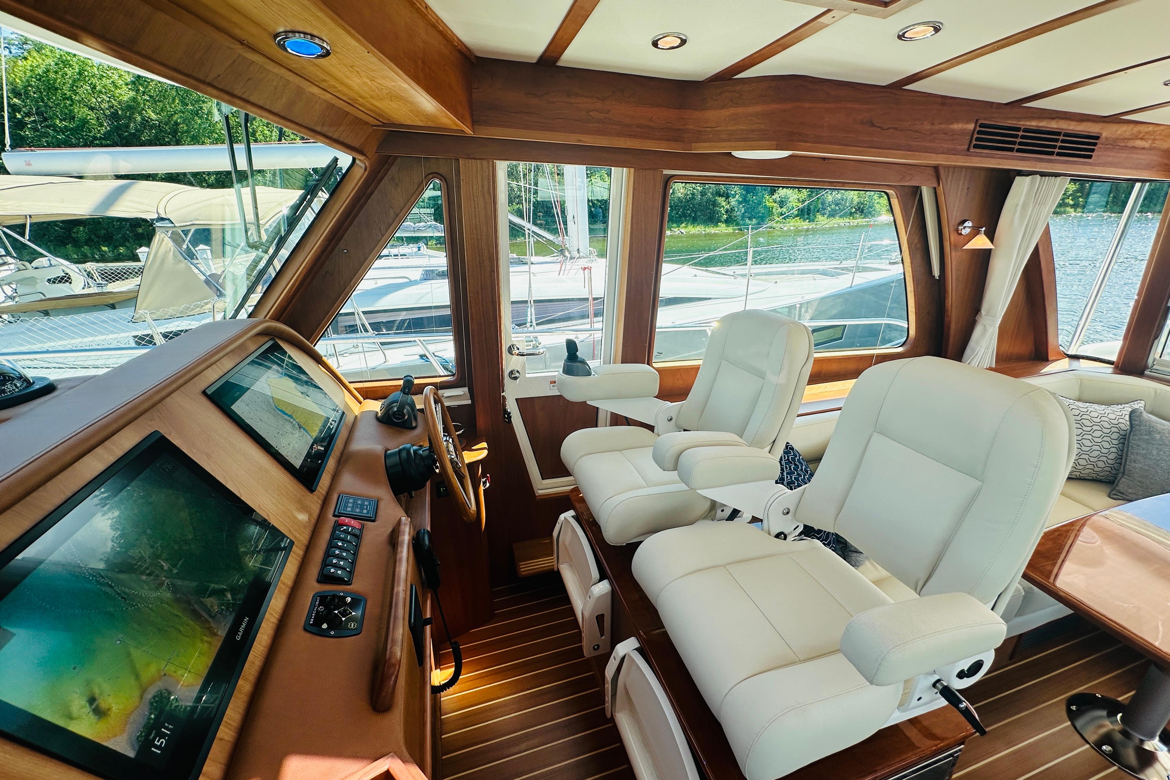 Interior of 2025 Sabre 48 Salon Express yacht with luxurious seating and navigation controls.