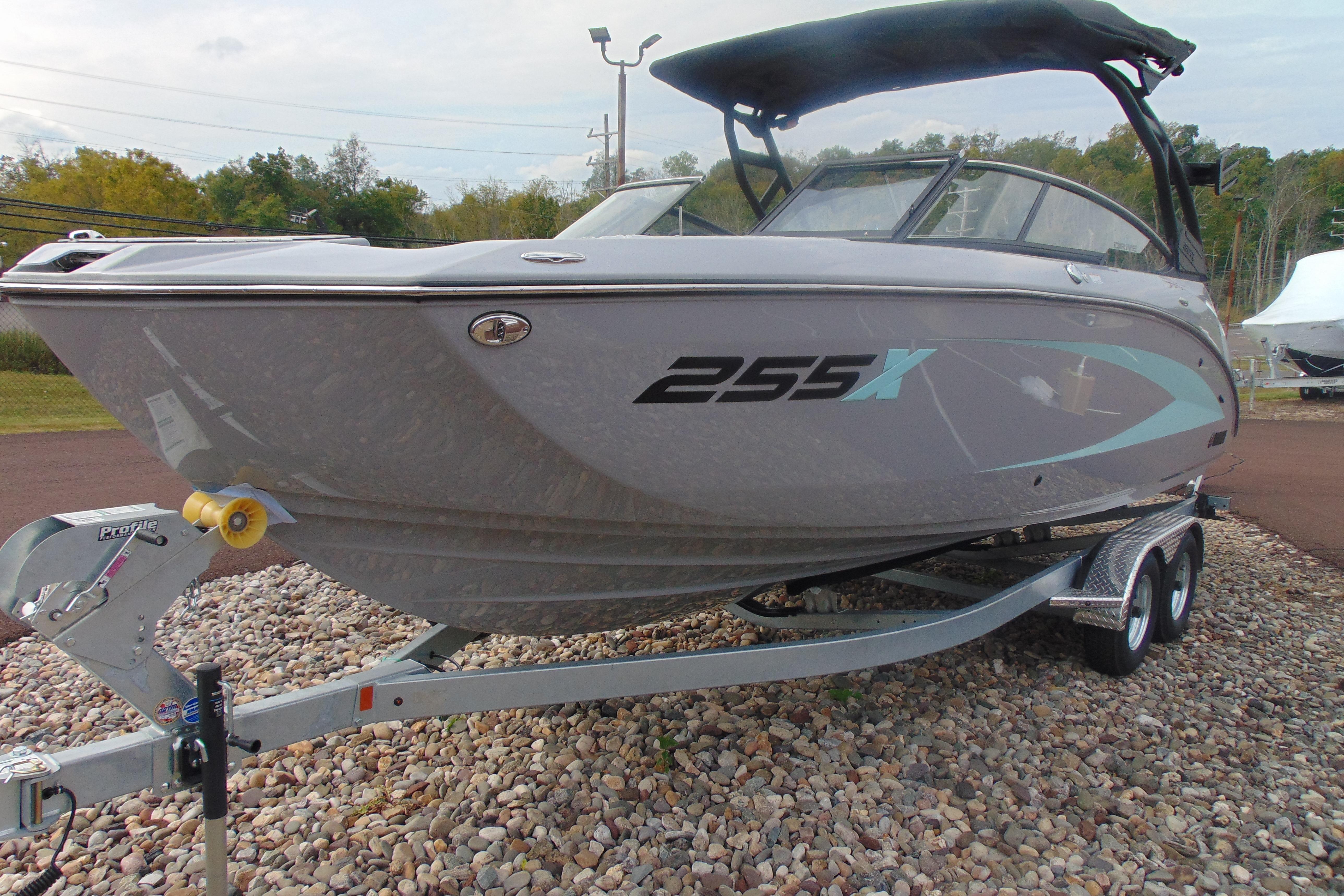 2026 Yamaha Boats 255XD on trailer, sleek design, gray exterior, parked on gravel.