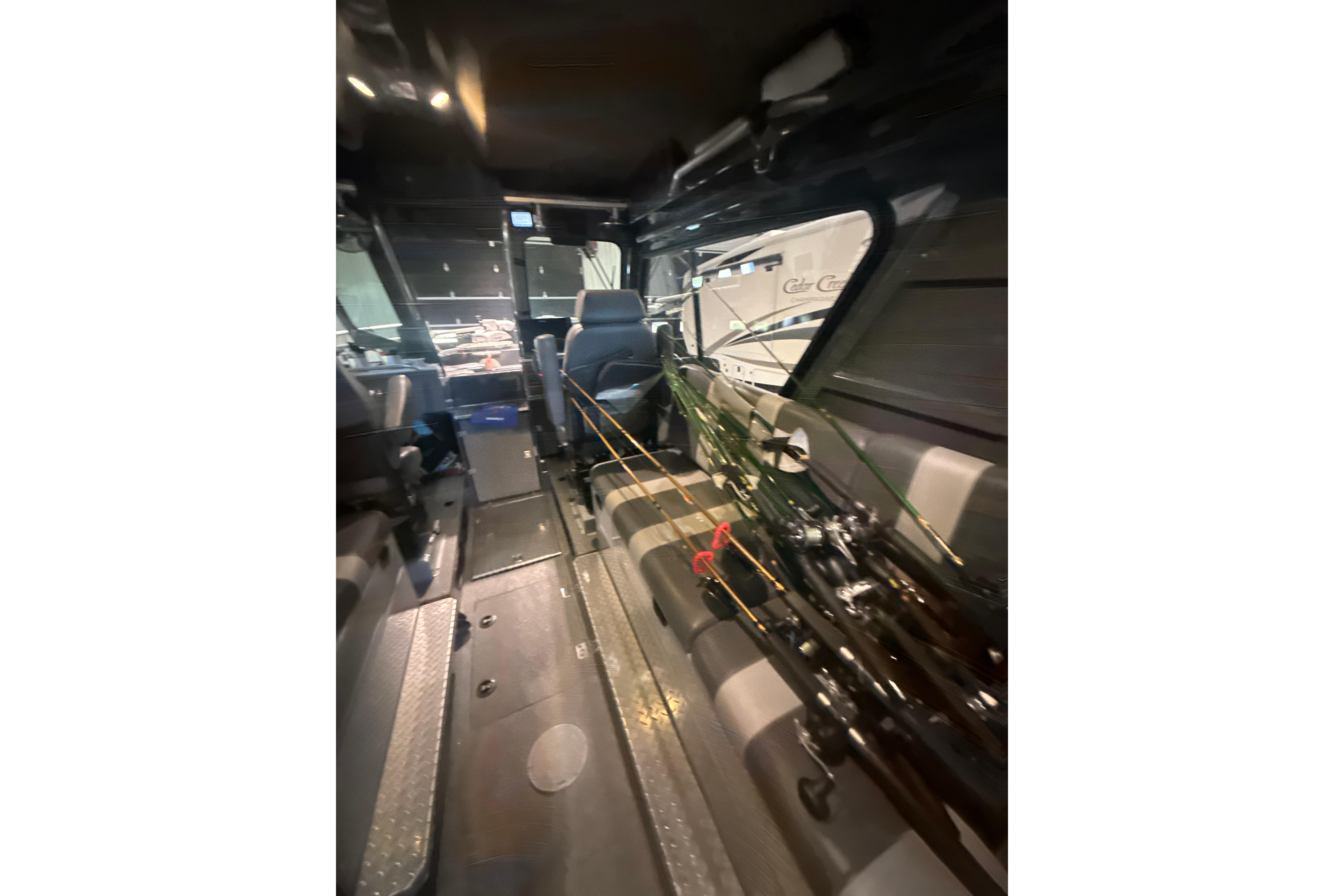 Interior of 2022 Hewescraft 270 Alaskan Hardtop with fishing rods and seating.