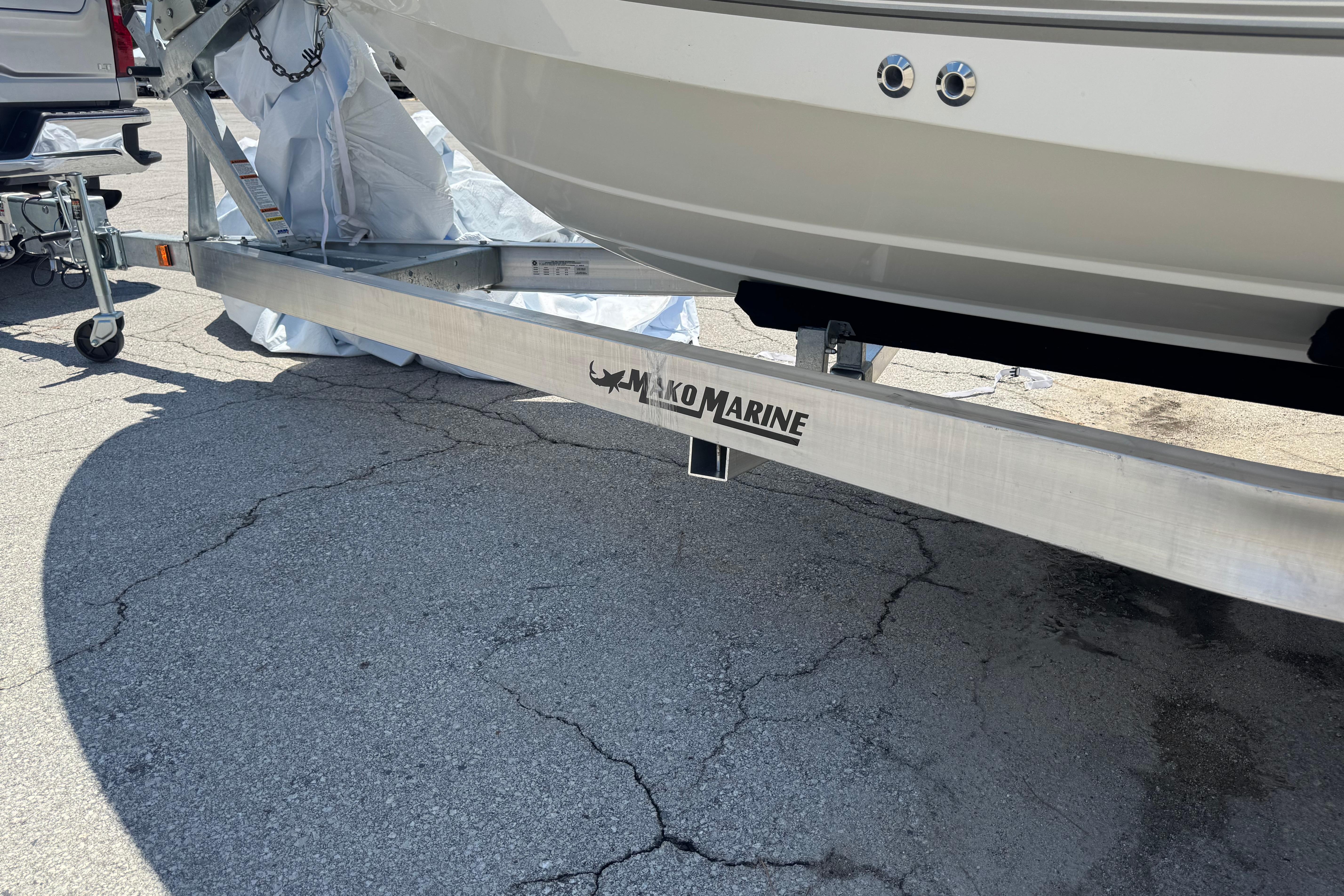 Trailer for 2026 Mako 214 Center Console boat on pavement.