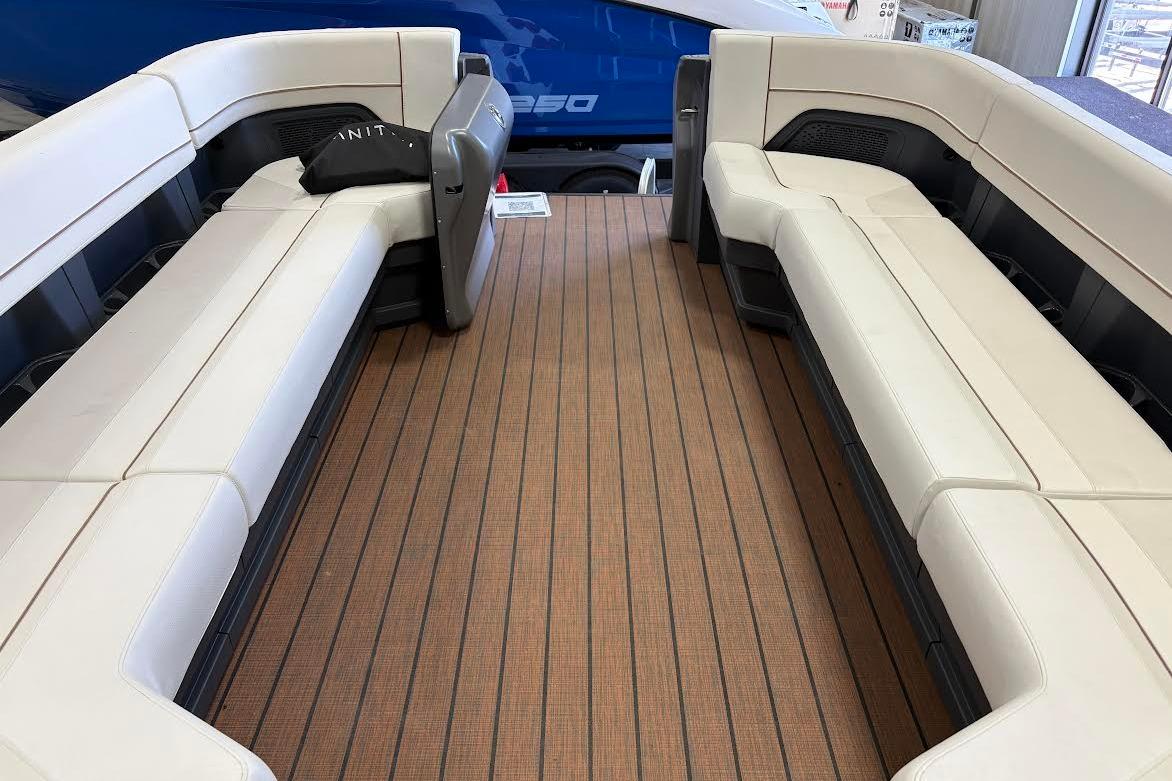 2023 Manitou EXPLORE 26 SHP 575 boat interior with beige seating and wooden flooring.