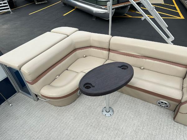 The image shows a beige corner bench with a round table on a boat.