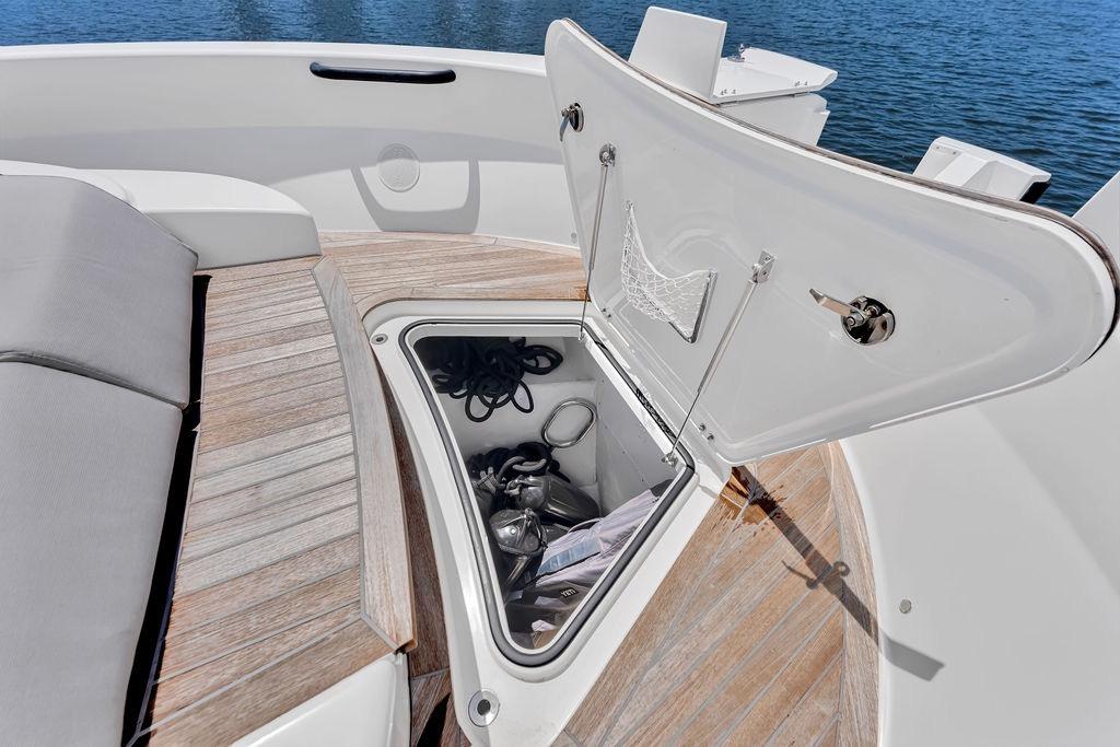 Open storage compartment on 2021 Bluegame BG 42 yacht, featuring wooden deck and ocean view.