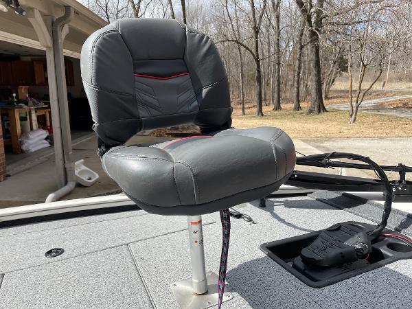 Gray seat on 2021 Tracker Pro 195 XTE boat deck, surrounded by trees.