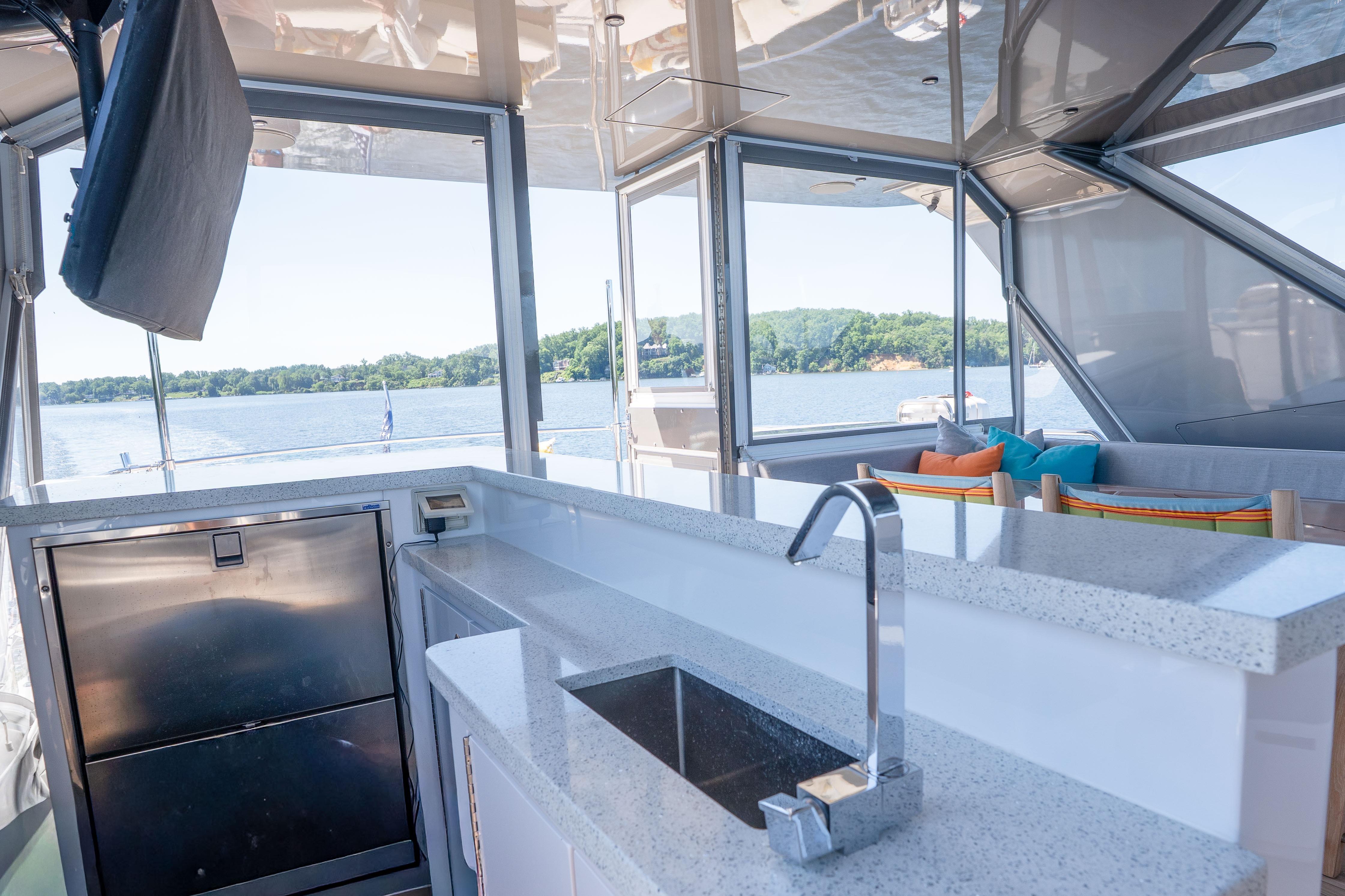 Luxurious 2021 Hatteras M75 Panacera yacht interior with modern kitchen and scenic water view.