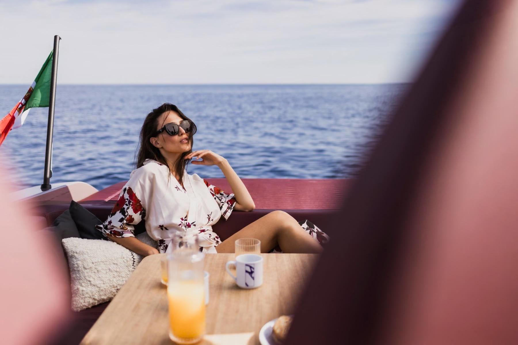 Woman relaxing on 2026 Cranchi A32 Luxury Tender, enjoying ocean view.