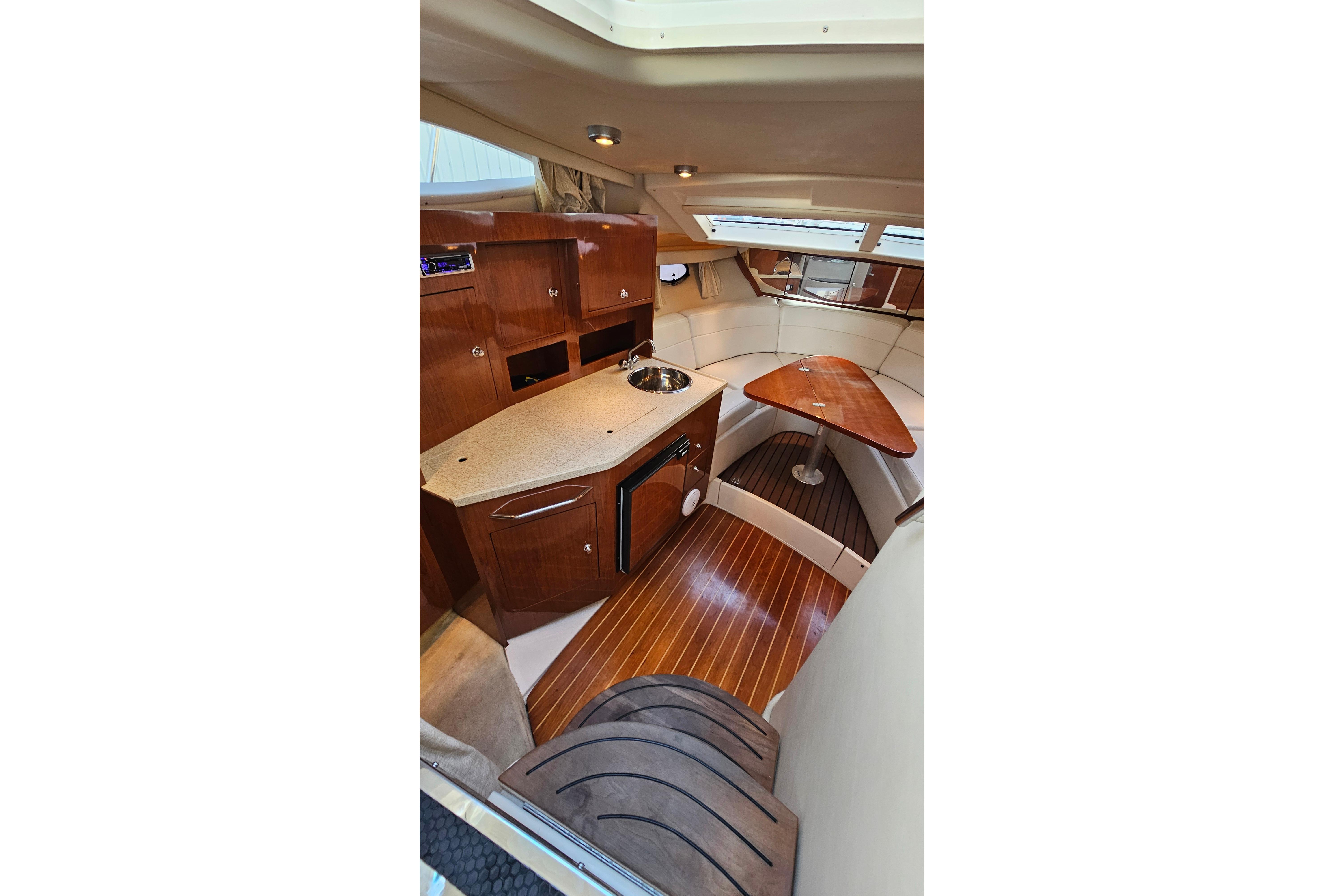 Interior of 2005 Regal 3060 Window Express boat with wood cabinetry and seating area.
