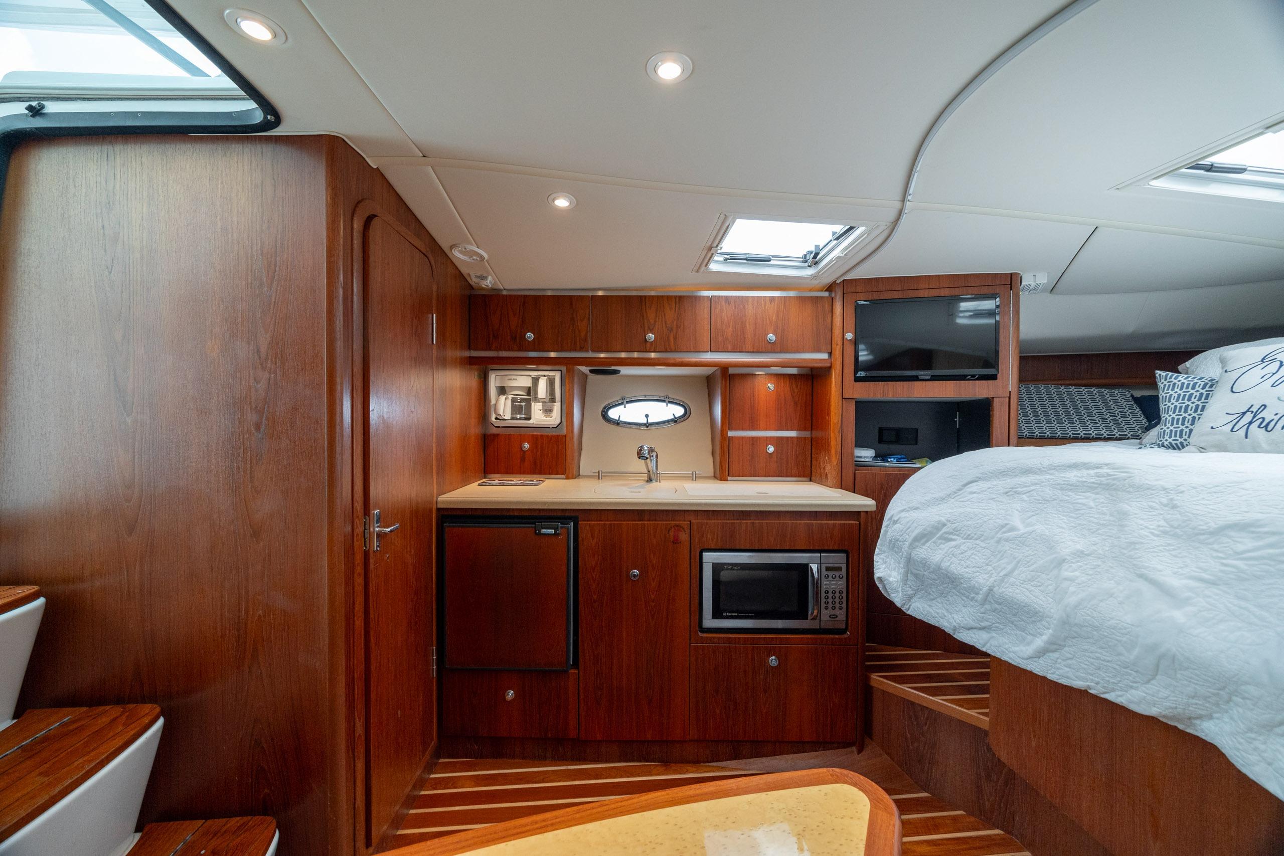 Luxurious interior of 2004 Tiara Yachts 3200 Open with kitchenette and bed.