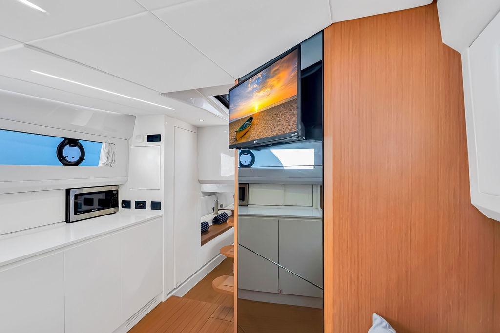 Interior of 2021 Bluegame BG 42 yacht with modern kitchen and TV.