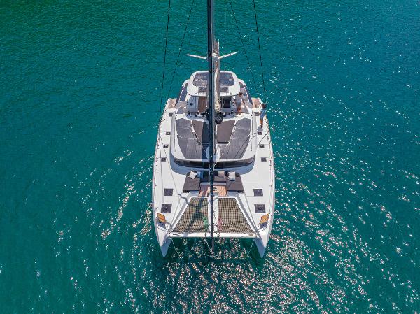 Aerial view of 2025 Lagoon 51 ICONIC catamaran on turquoise water.
