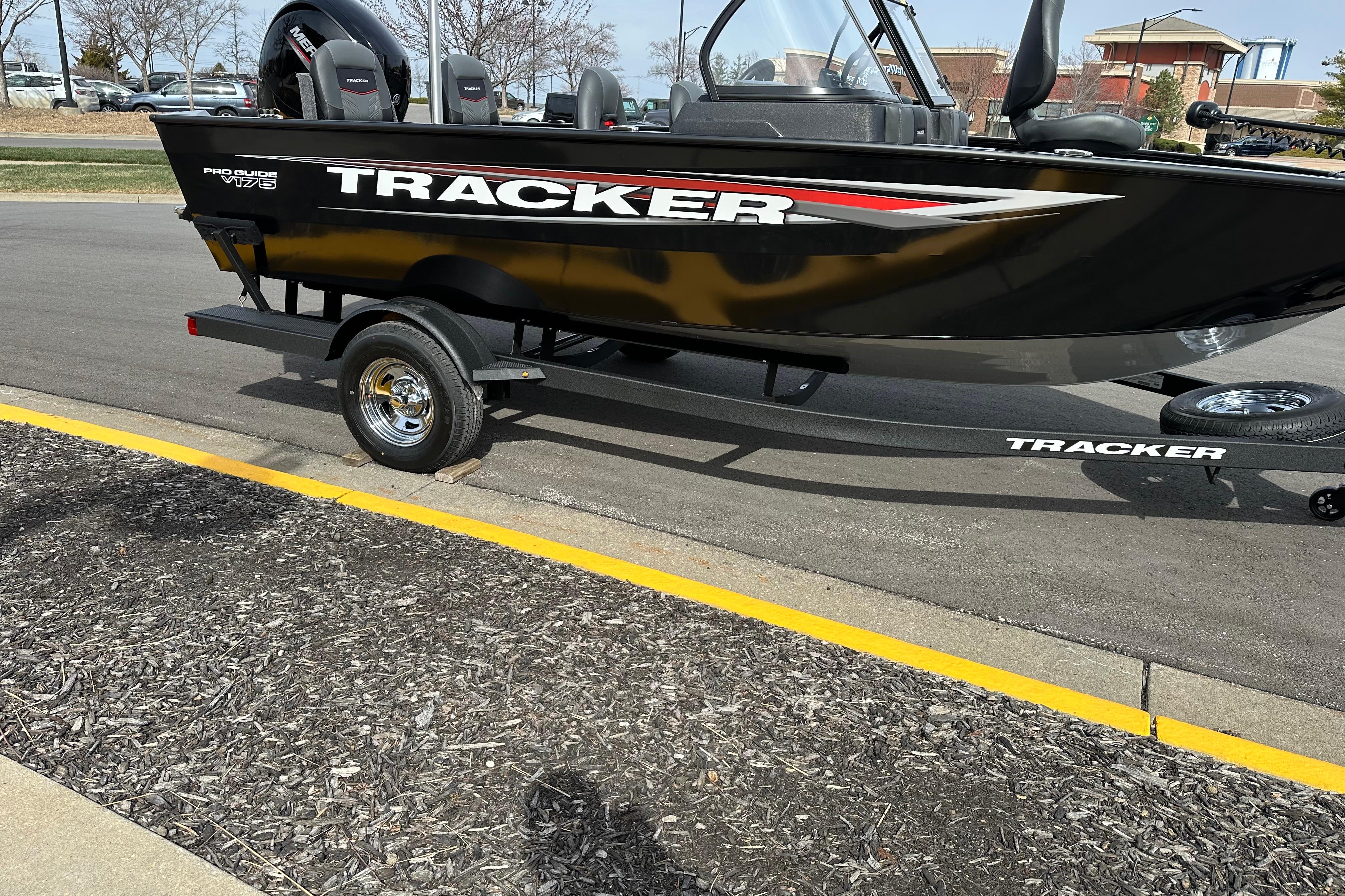 2026 Tracker Pro Guide V-175 Combo boat on trailer, parked on asphalt.