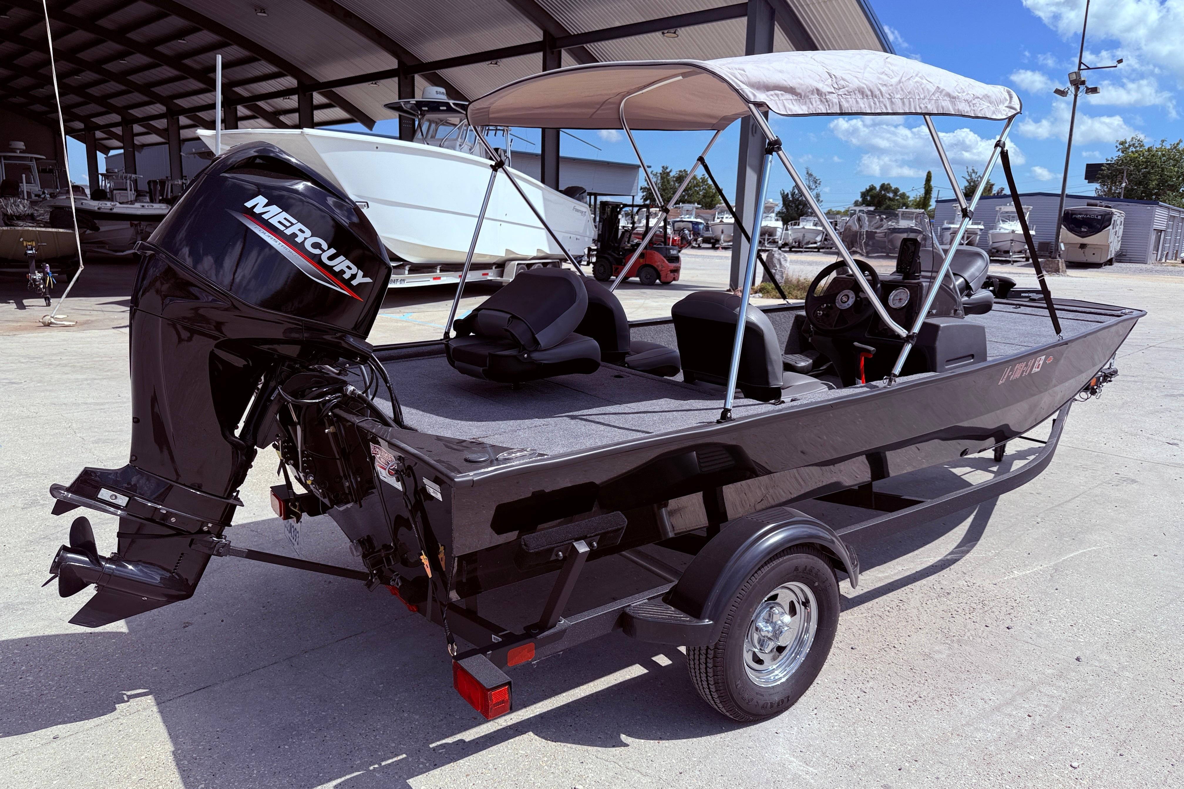 2025 Bass Tracker Classic XL boat with Mercury engine, parked under a canopy.