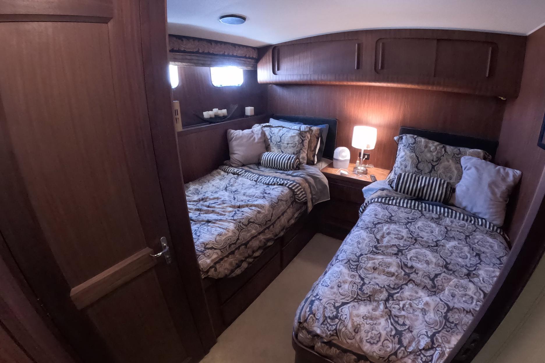 Interior of 1987 Hatteras 54 Motor Yacht with twin beds and elegant decor.