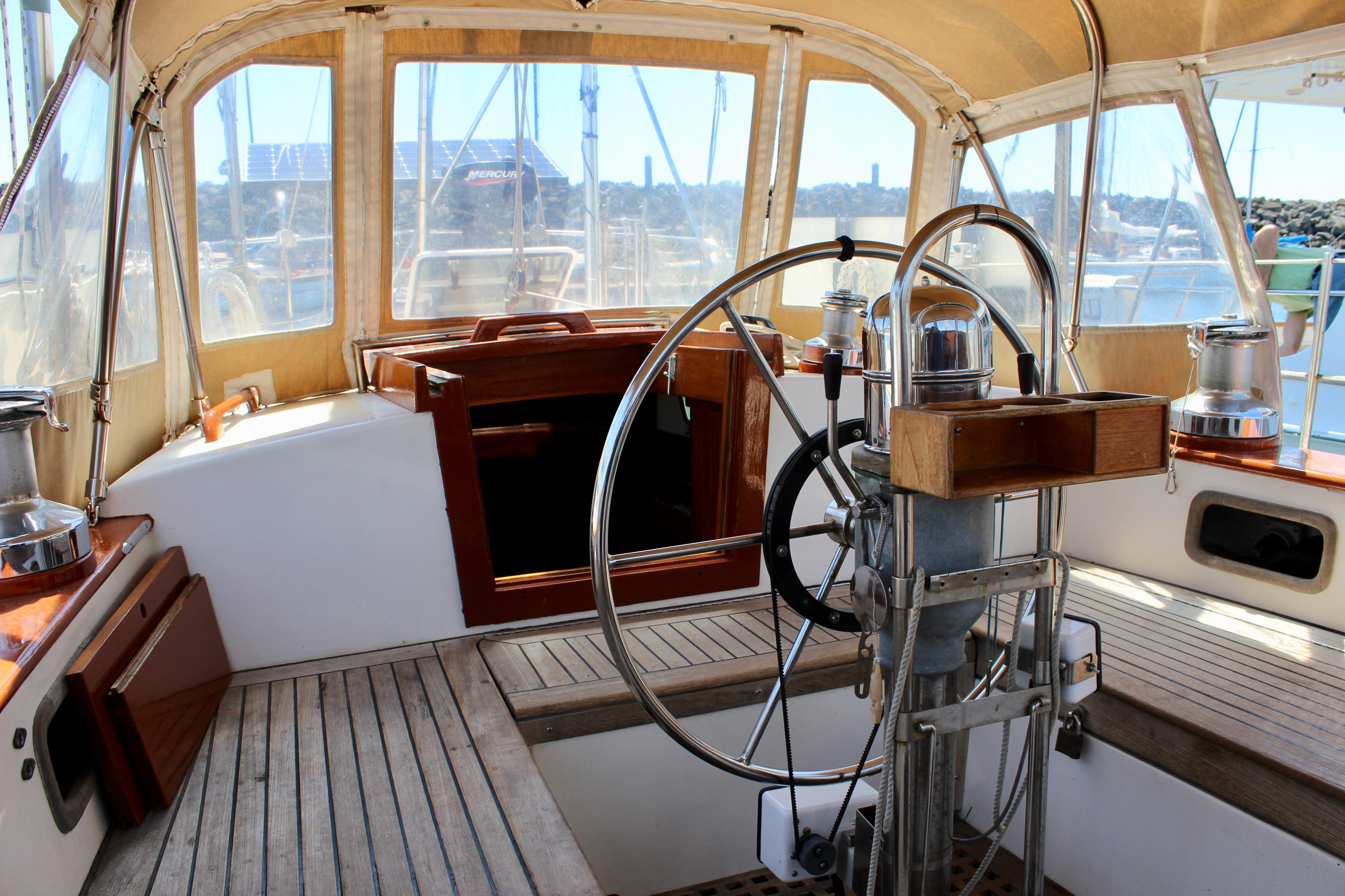 Cockpit of 1981 Kelly Peterson 46 sailboat with wooden accents and steering wheel.