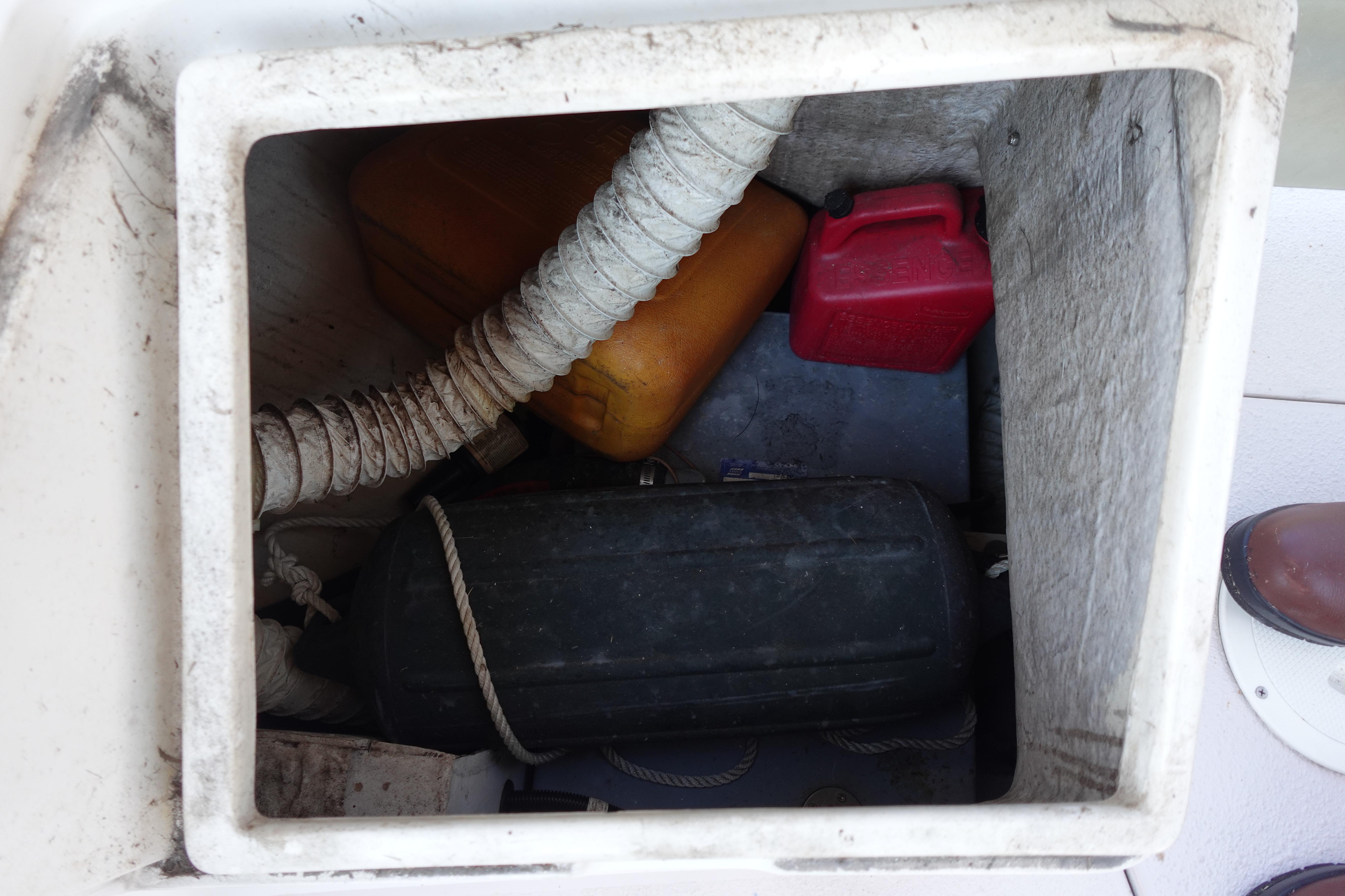 Storage compartment of a 1997 Catalina 28 sailboat with fuel containers and equipment.