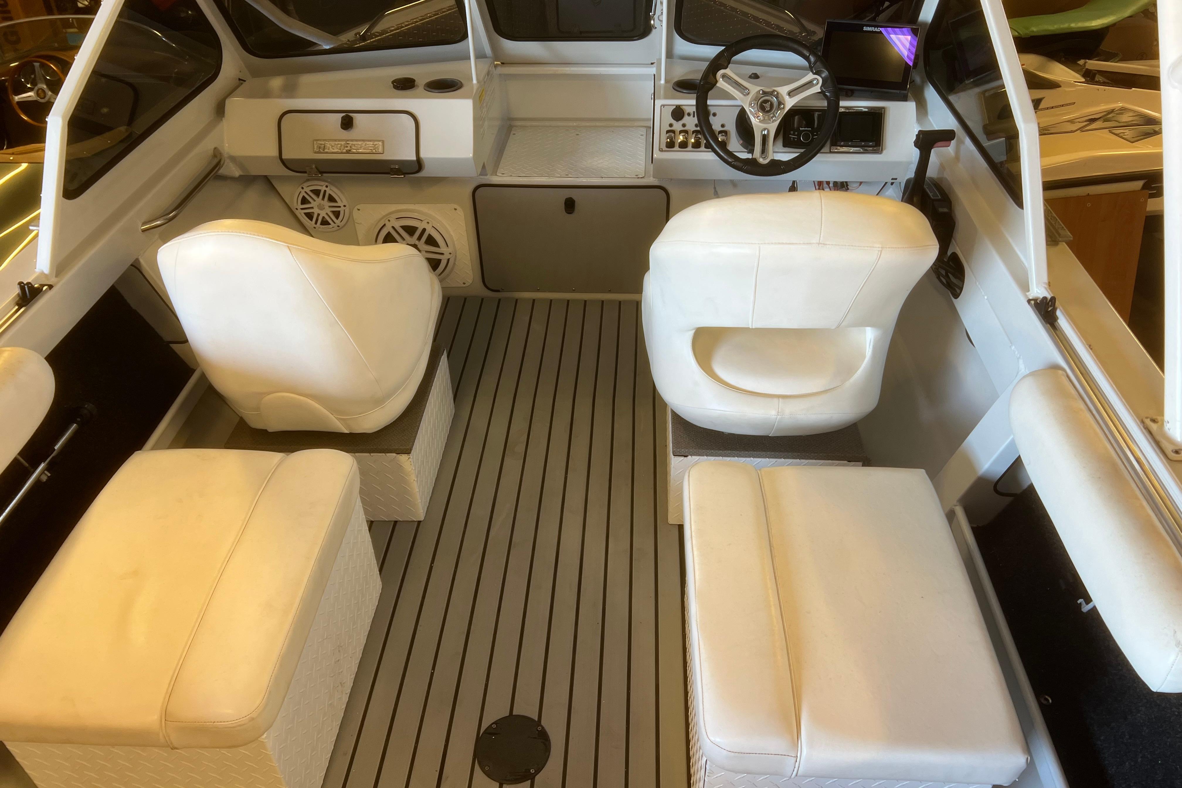 Interior of 2019 KingFisher 1825 Falcon boat with white seating and modern dashboard.