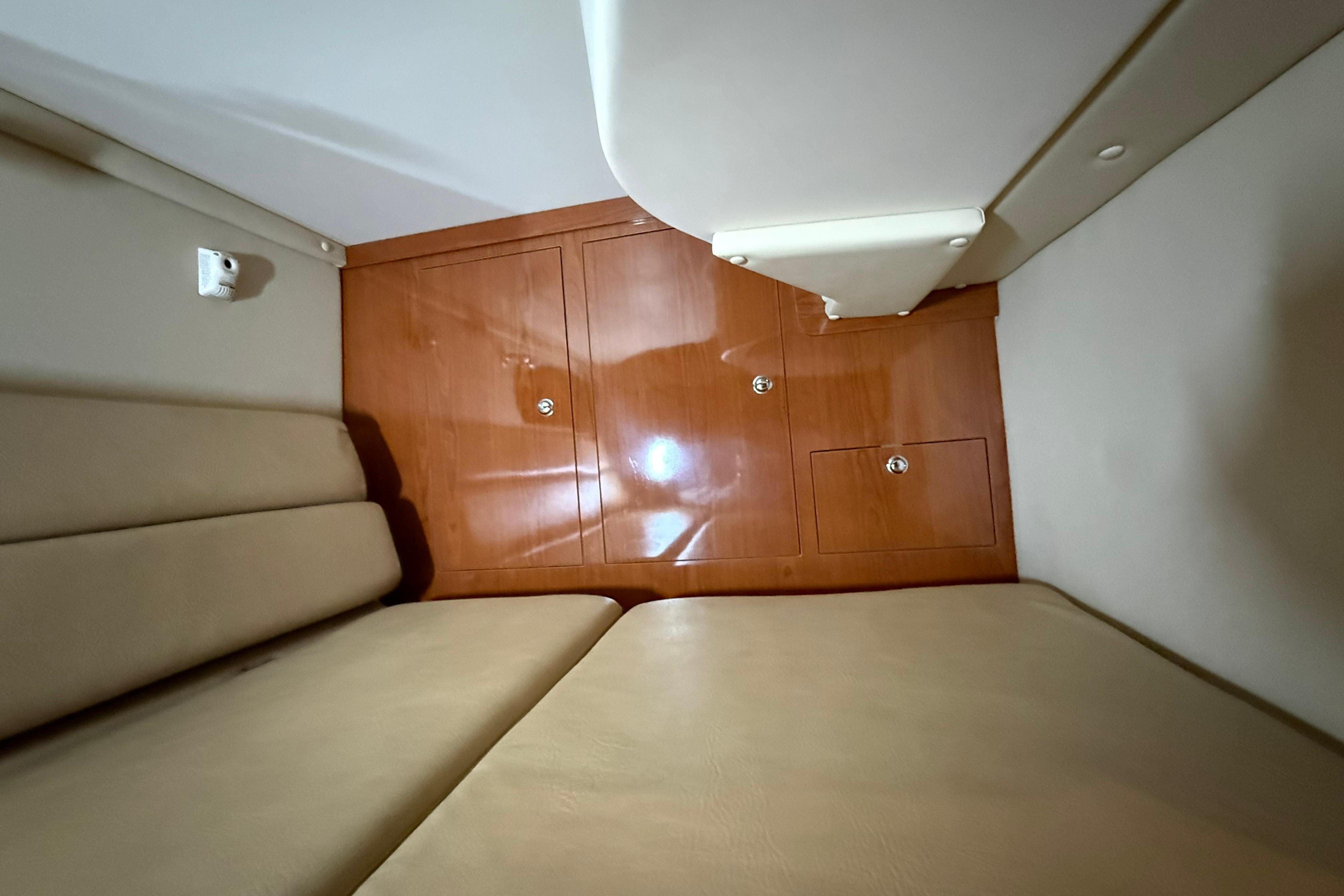 2007 Regal Commodore 3760 IO cabin interior with beige seating and wooden cabinetry.