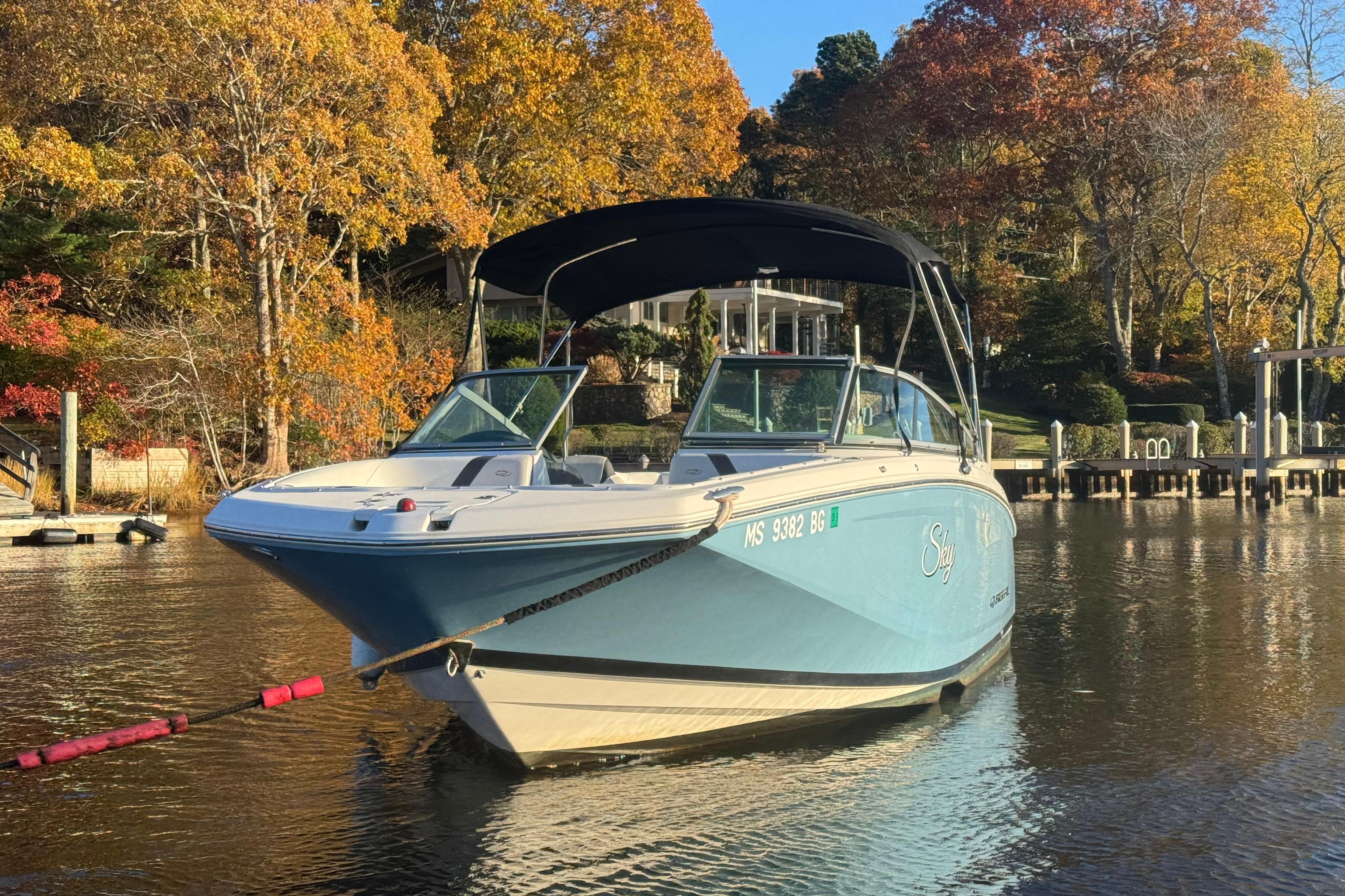 2017 Regal 23 OBX boat on a serene lake with autumn foliage.