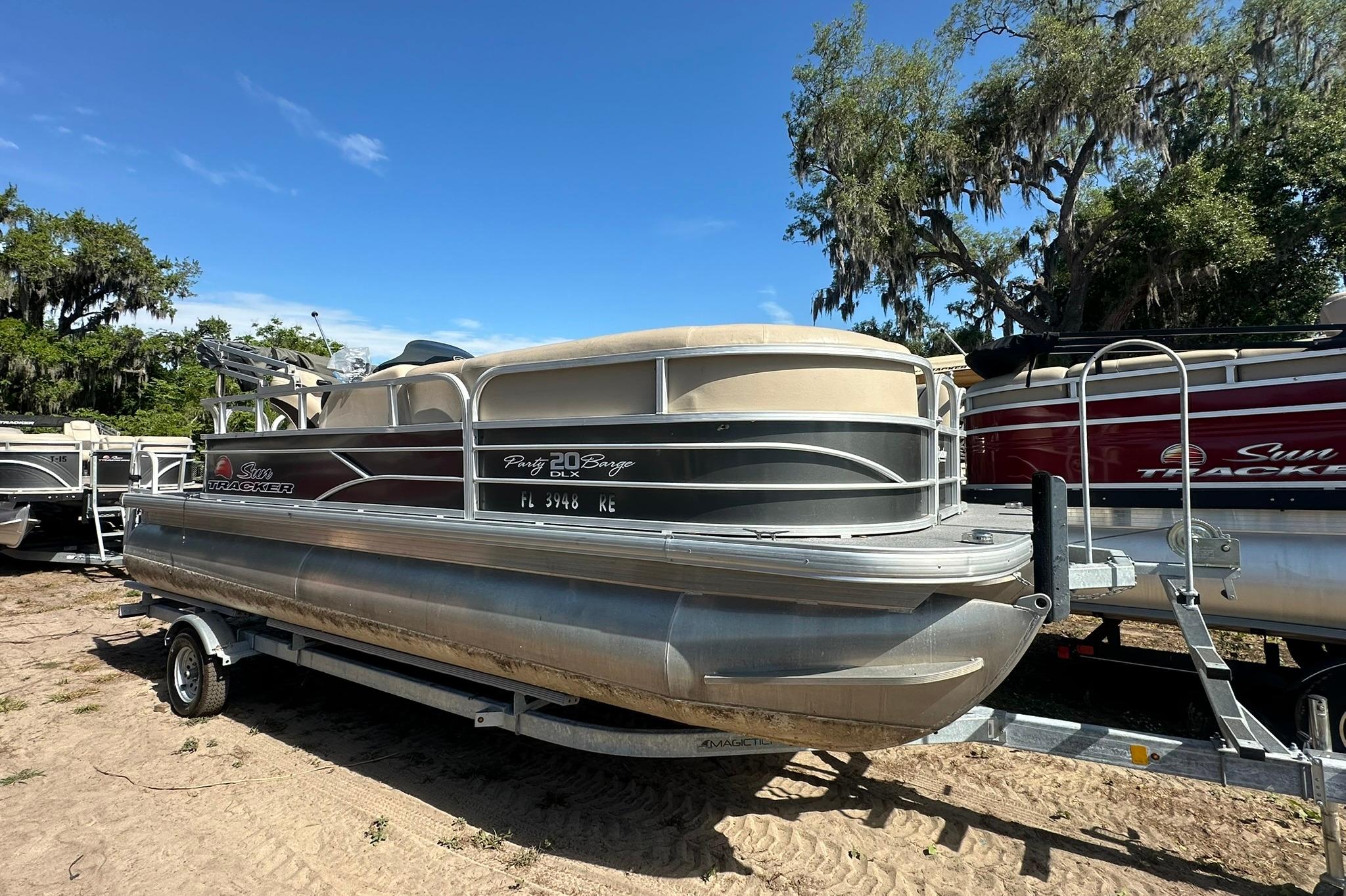 2016 SUNTRACKER Party Barge 20 pontoon boat on trailer, parked outdoors.