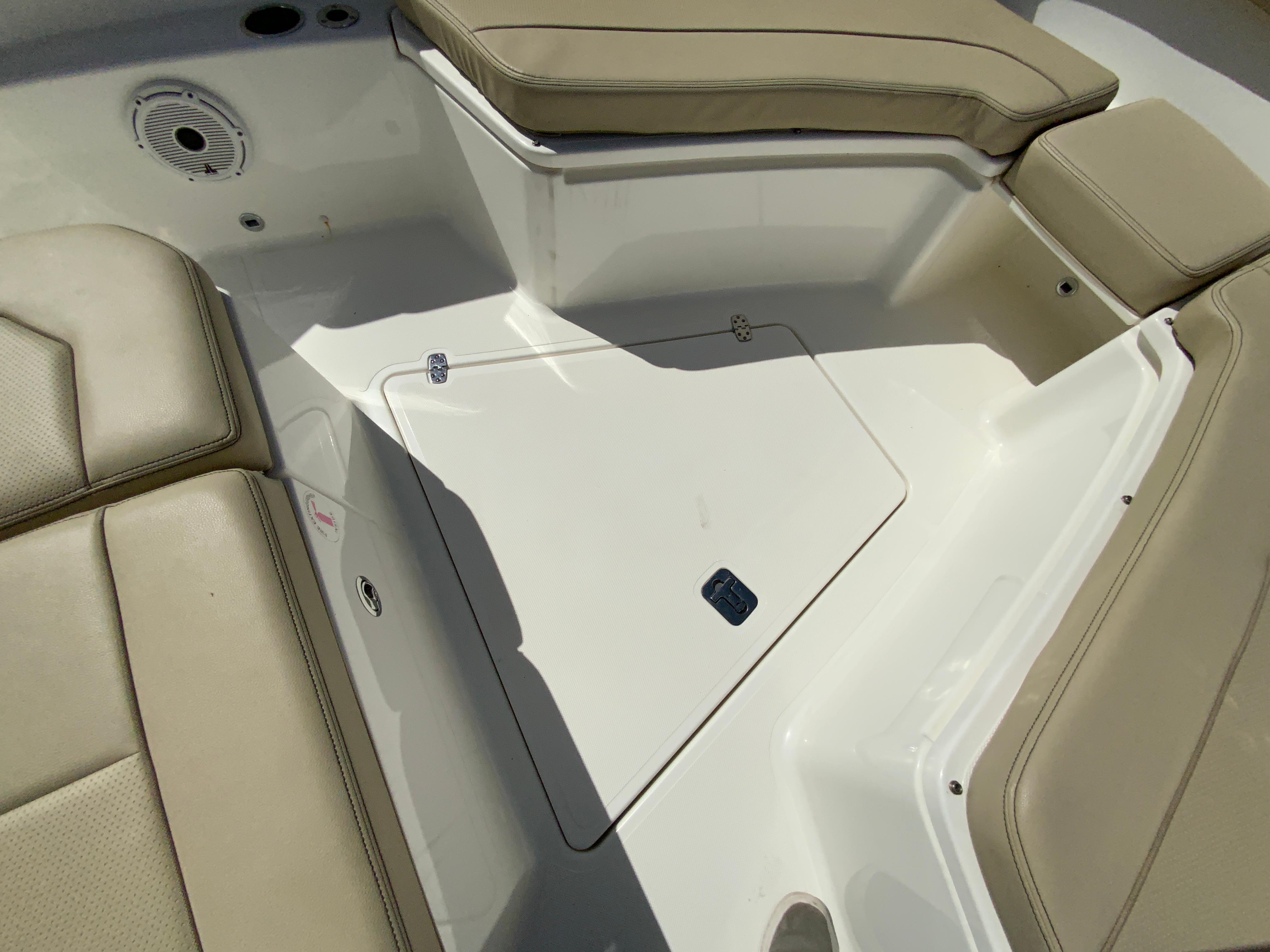 2020 Pursuit S 288 Sport boat interior with beige seating and storage compartment.