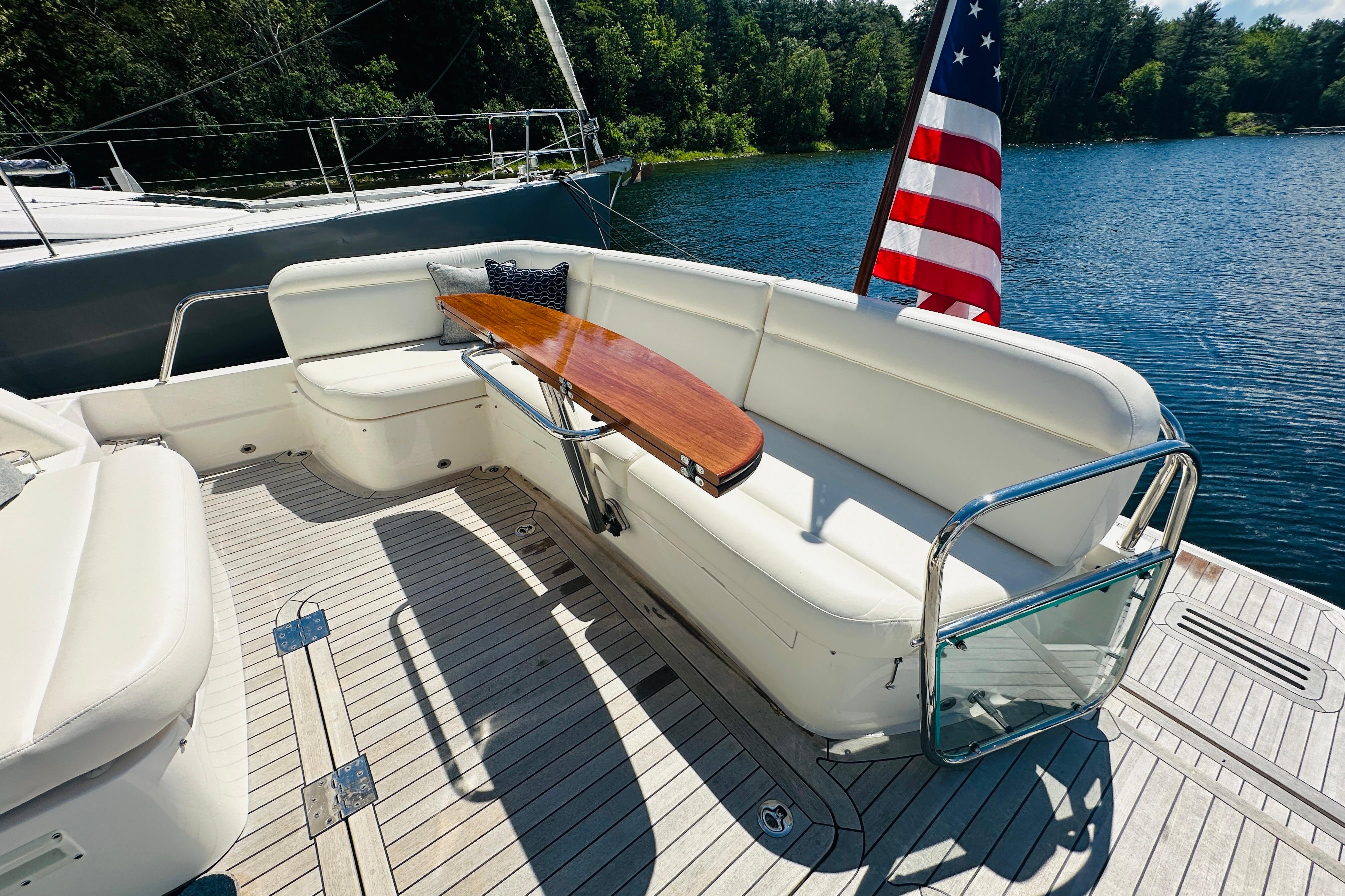 Luxurious 2025 Sabre 48 Salon Express yacht deck with seating and American flag.
