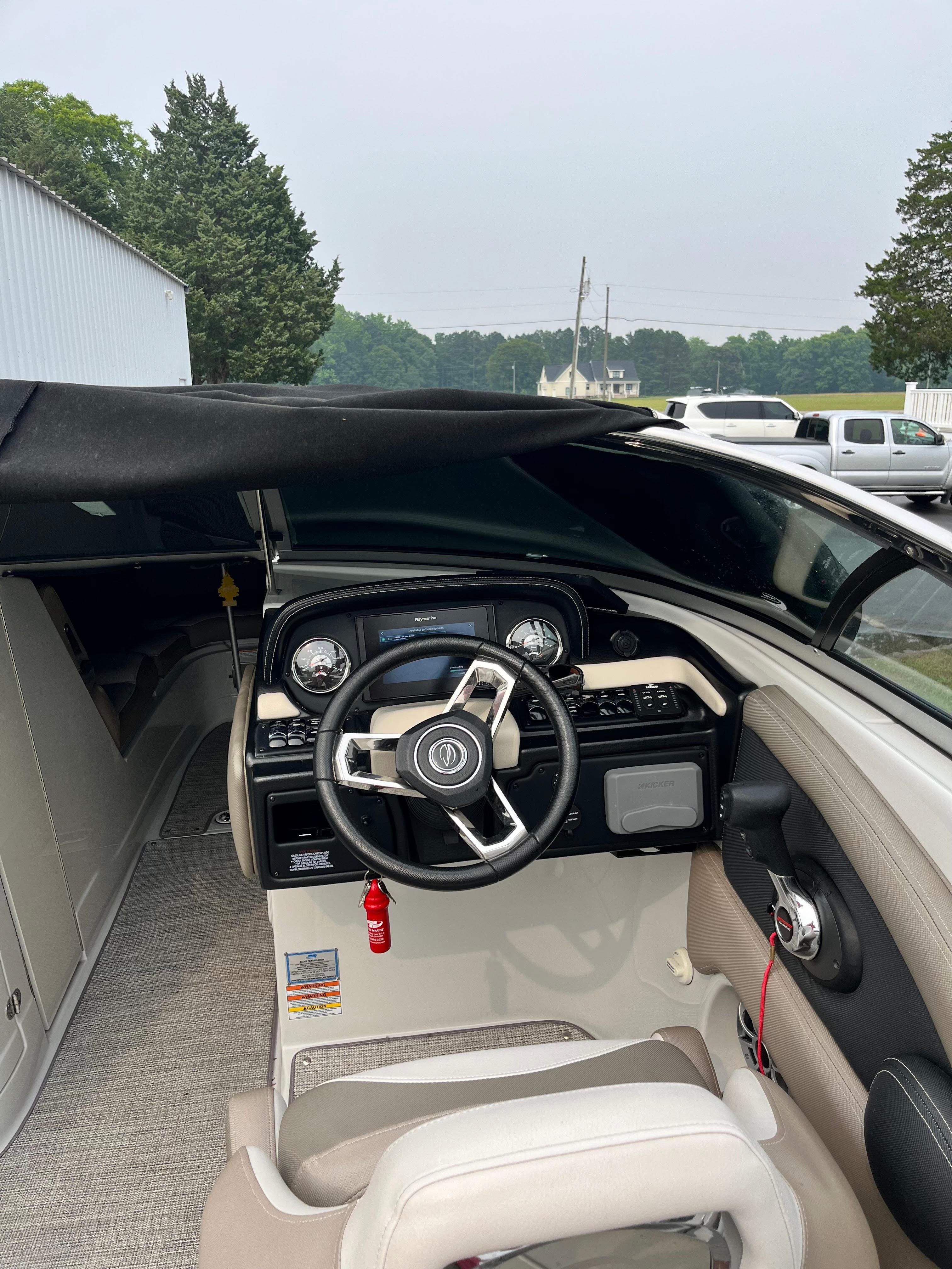 The image shows the cockpit of a 2019 Crownline E 285 boat with a modern helm.