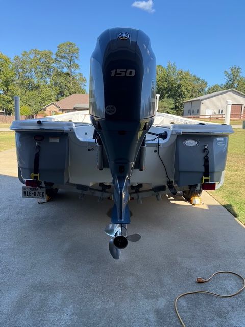 A NauticStar 215 XTS boat is on a trailer in a driveway.