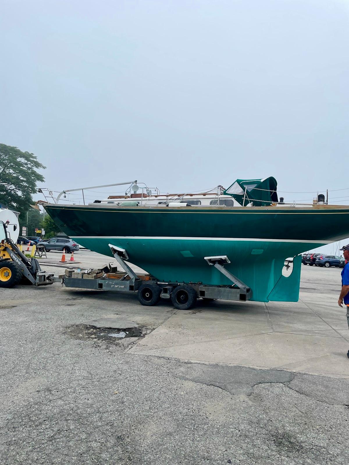 1981 Bristol 40 sailboat on trailer in a parking lot, overcast sky.