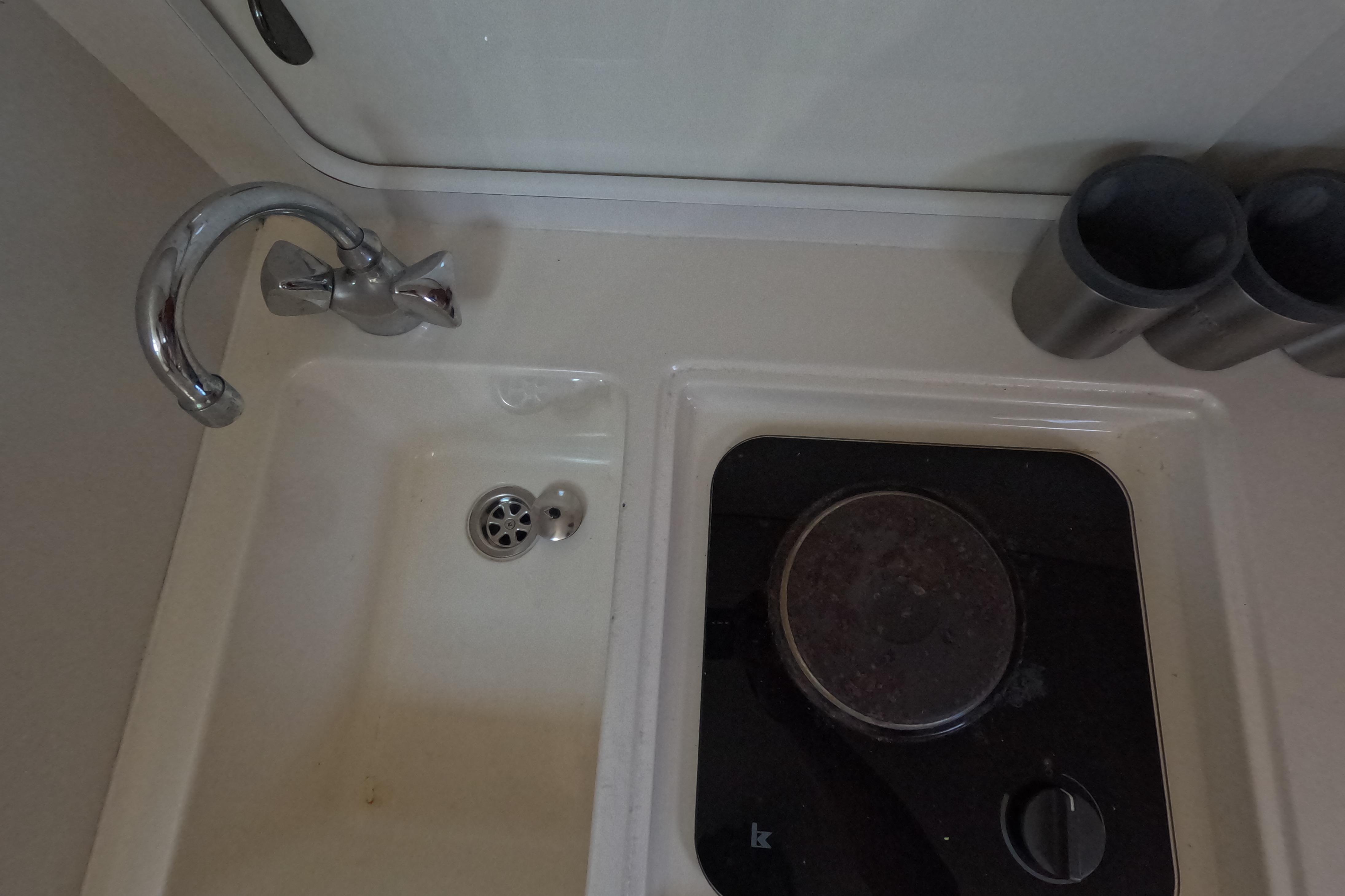 Compact kitchen area in a 1995 Tiara Yachts 2900 Open, featuring a sink and stove.