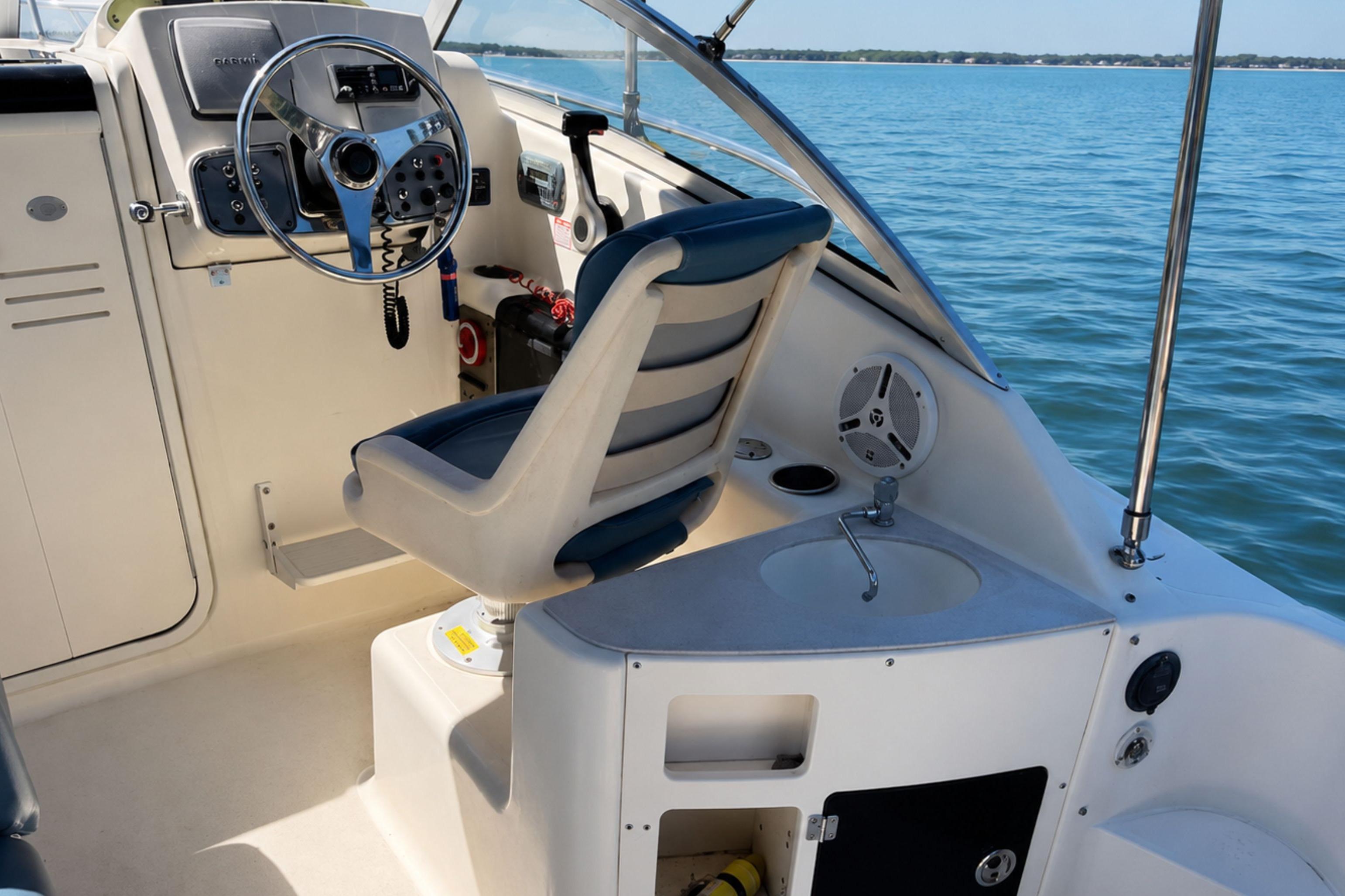 2008 Scout 222 Abaco boat interior with steering wheel and seating, on calm blue water.