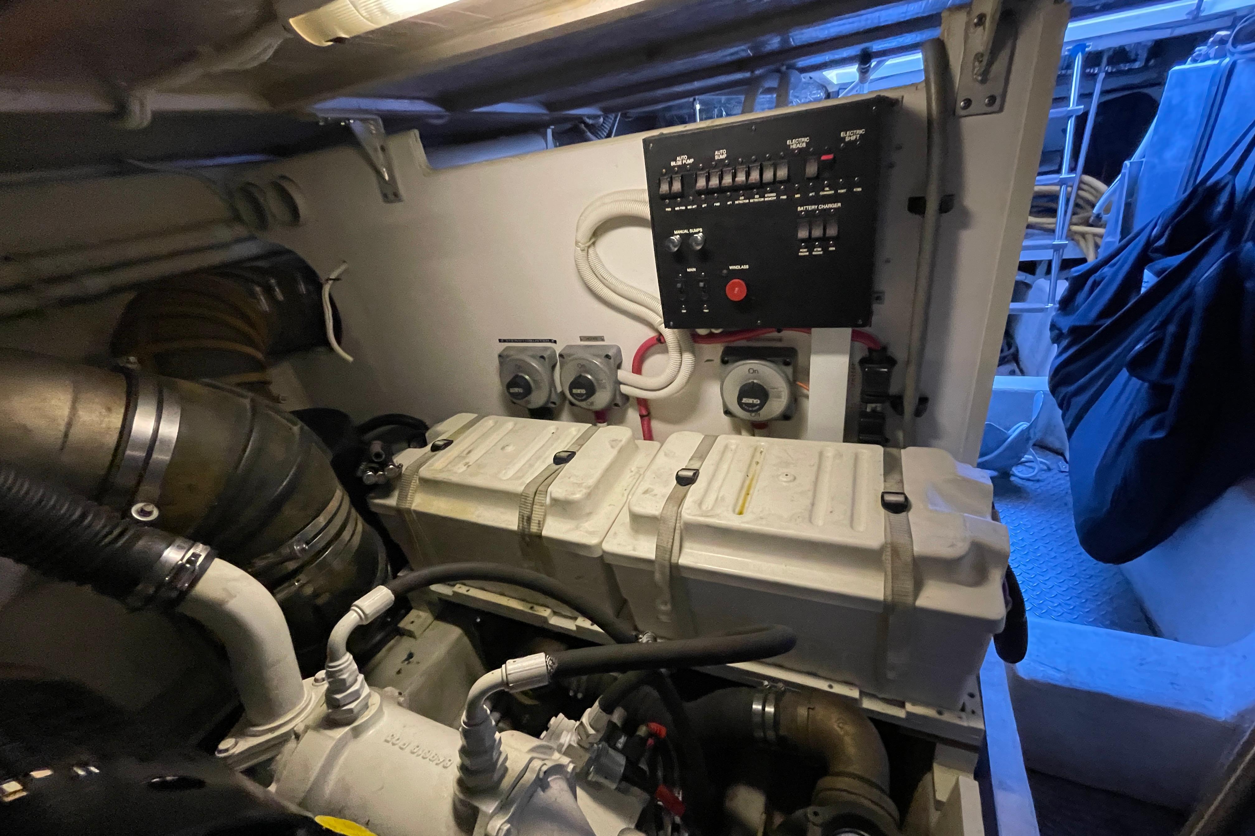 Engine room of 2002 Carver 570 Voyager Pilothouse with control panel and machinery.