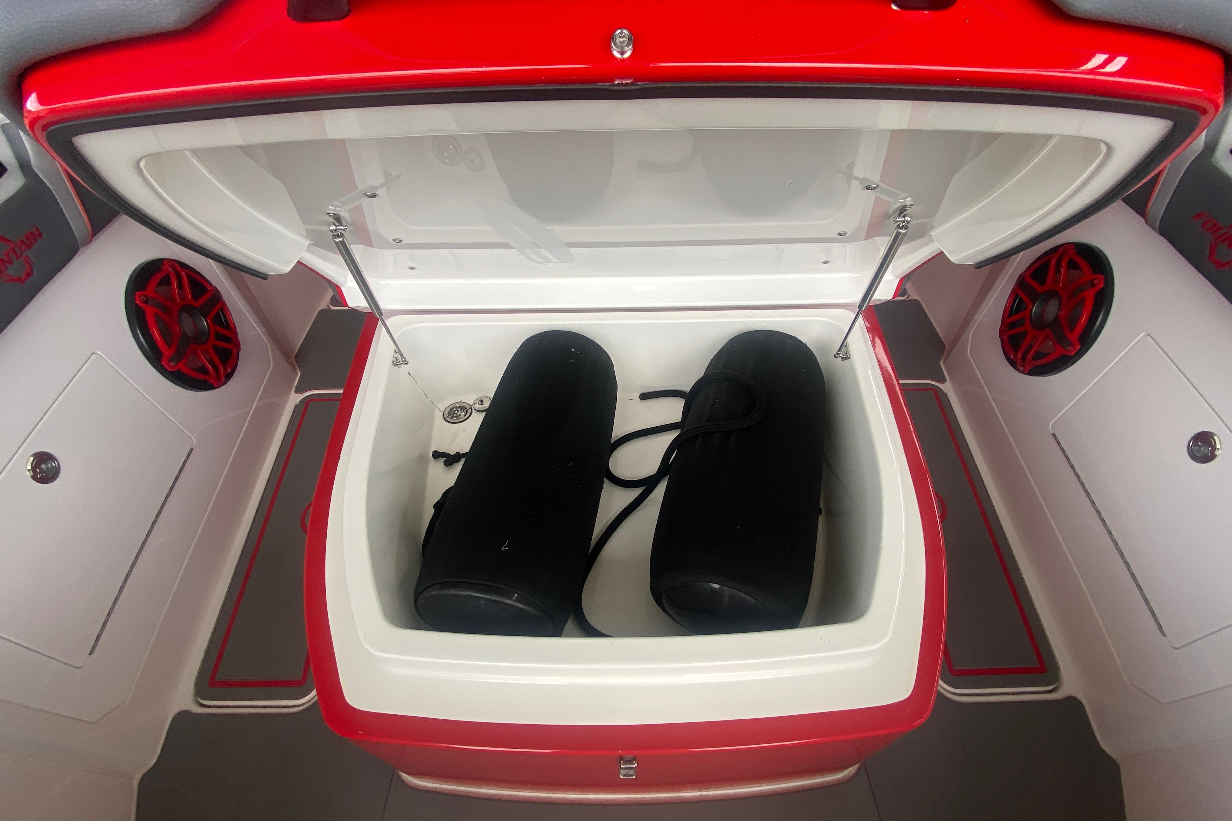 Open storage compartment in 2025 Fountain 38 SCX boat with speakers and fenders.
