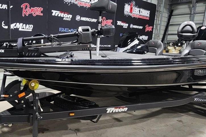 2026 Triton 20XP Patriot boat on display in a showroom with branded backdrop.