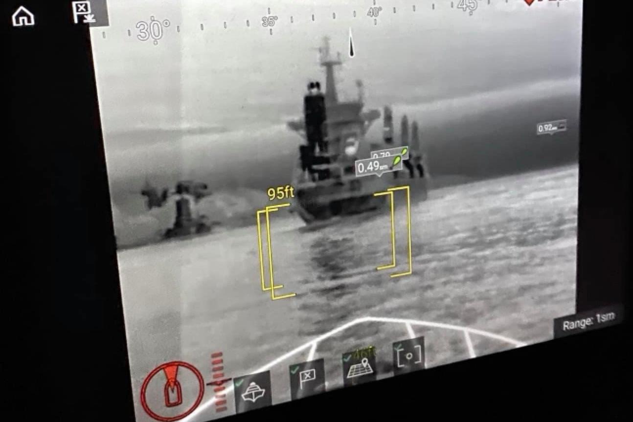 Thermal imaging display showing a ship at sea, with distance measurements and navigation data.