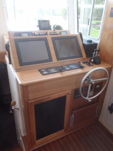 Helm station of 2025 Great Harbour N40 with dual screens and wooden finish.