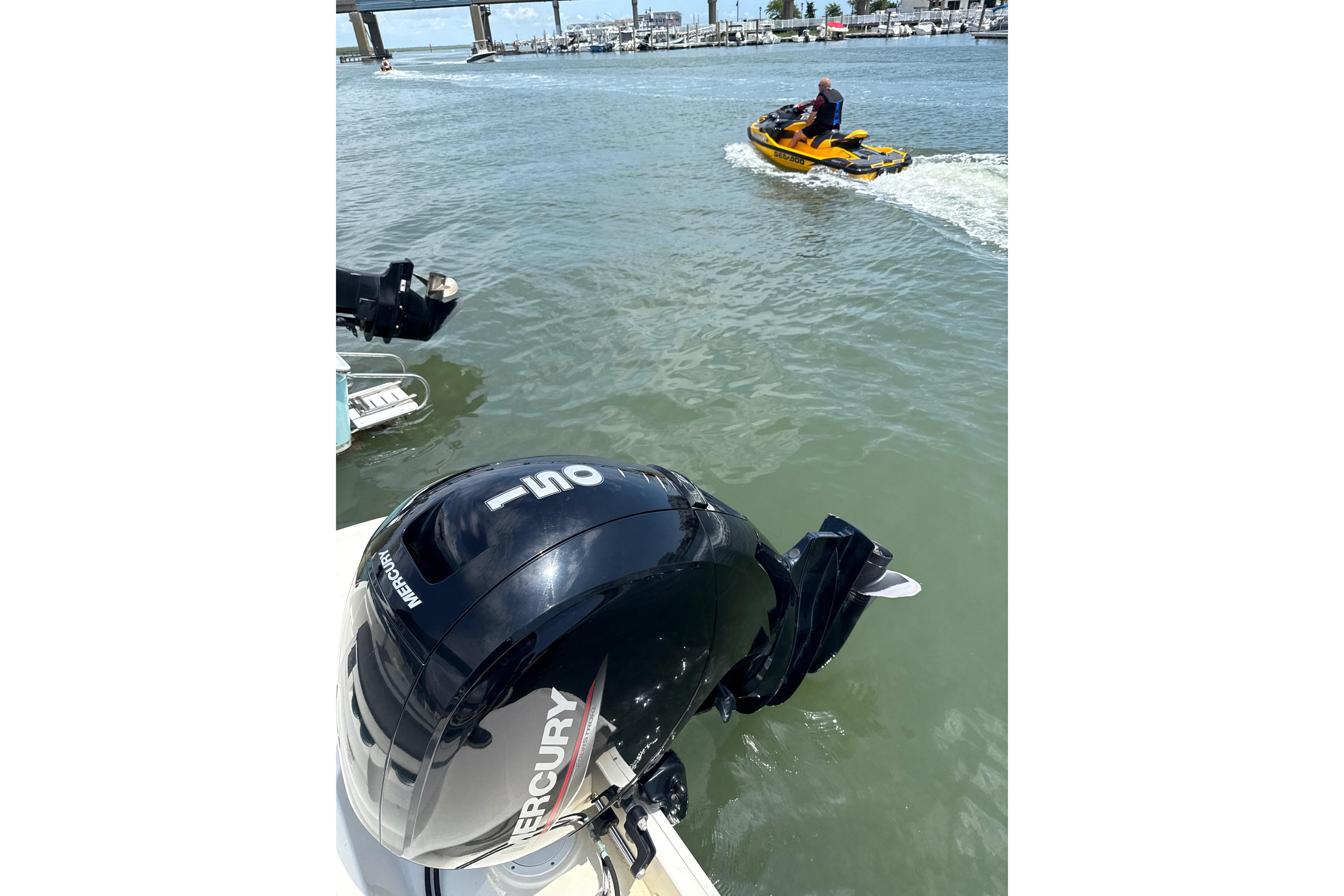 2023 Bayliner VR6 Bowrider OB with Mercury outboard engine on water, jet ski nearby.