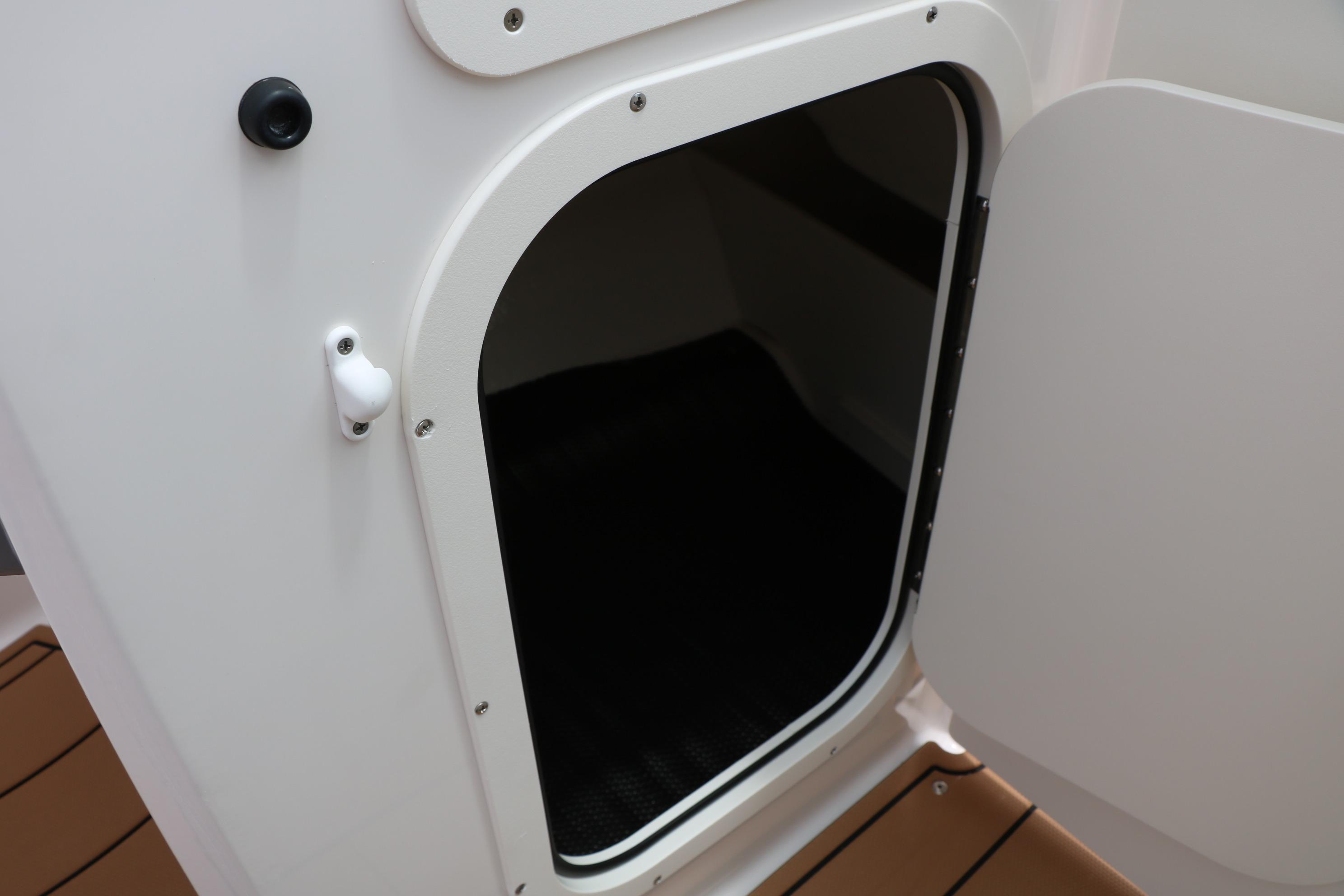 2025 Chaparral 23 SSi boat storage compartment with open door.